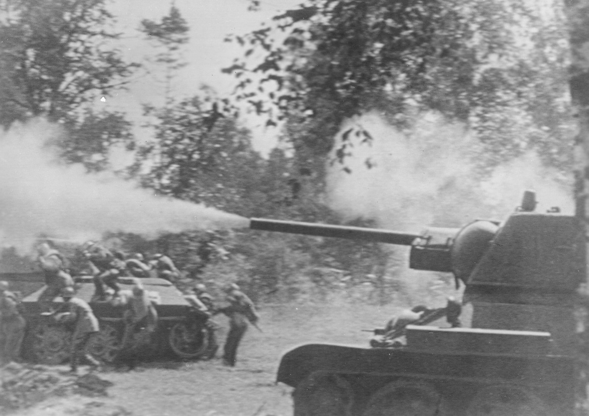 “March of Time”, 2/11/1942. Russian tank, (R), fires point blank at enemy while from a companion tank (L), on which they had ridden into mouth of enemy guns, brave Russians jump to the attack.Credit: ACME Telephoto;