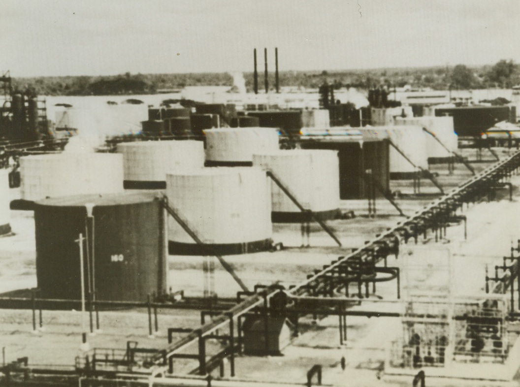 In Oil-Refining Area Threatened by Japanese, 2/15/1942. Netherlands East Indies.—Japanese troops poured ashore in Southern Sumatra today for a land drive on Palembang (60 miles inland), center of what probably is the richest single oil field between the Persian Gulf and the United States, but they were too late to save their vanguard of several hundred parachutists, who were all but wiped out yesterday, when they swooped down on Palembang oil refineries and other vital points.  Here is a general view of the giant standard oil company’s plant in Palembang. Credit line (from March of Time’s far East command from ACME);