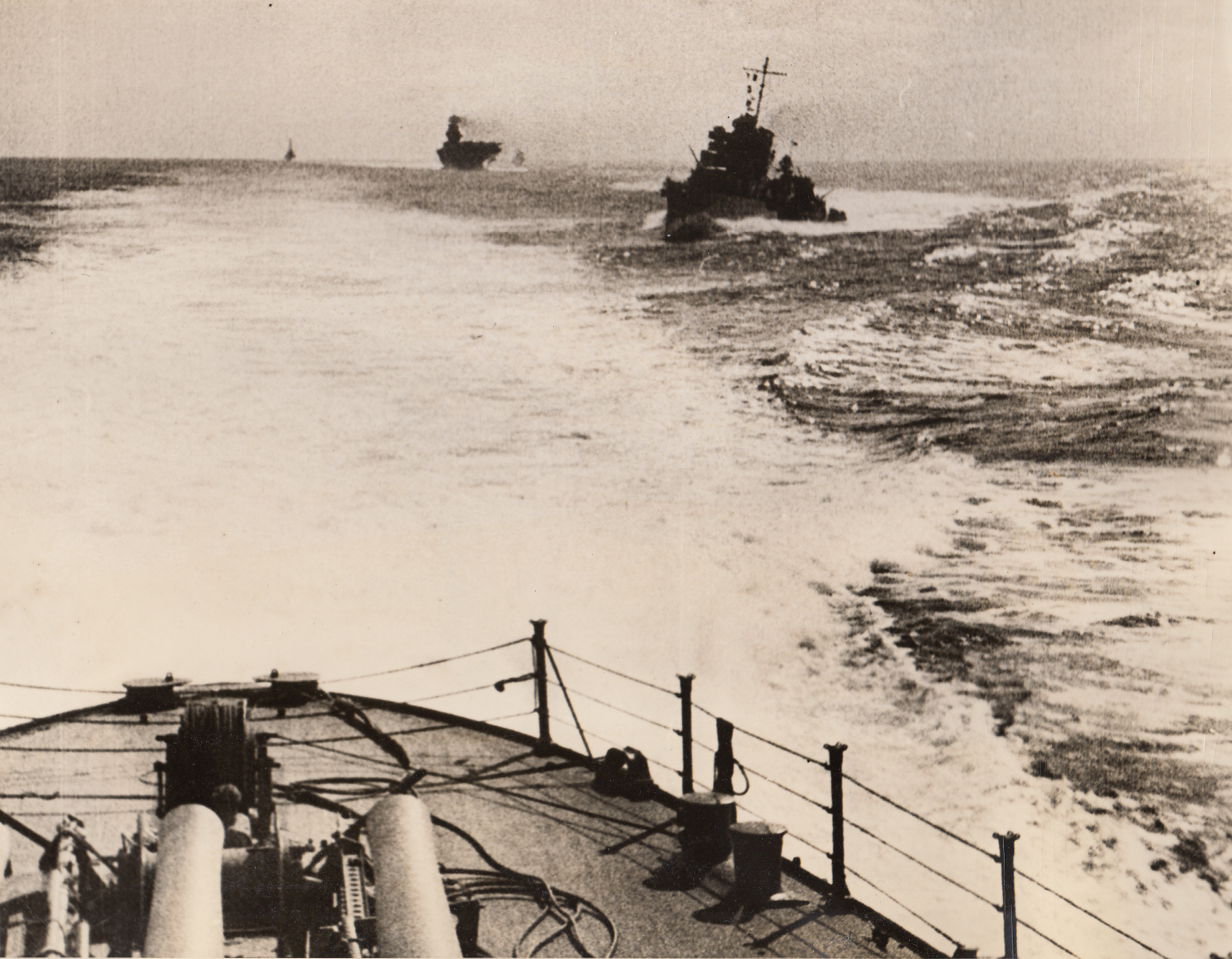 “The Fleet Is Not Idle . . .”, 2/14/1942. With the Pacific Fleet – Made from the deck of a U.S. warship, this photo shows other units of the Pacific Fleet, including an aircraft carrier in the background, speeding to the smashing attack on Japan’s Marshall and Gilbert Islands in the Western Pacific. Operations proceeded smoothly and before the U.S. warships retired they had smashed every enemy base, sunk numerous ships and downed 38 Jap planes, in partial repayment for Pearl Harbor.;