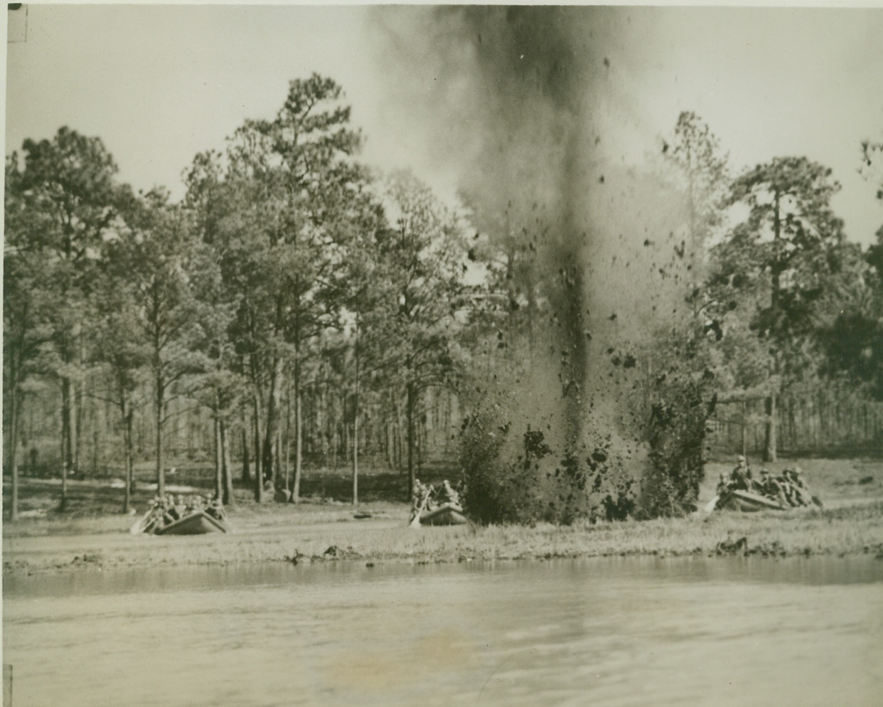 Uncle Sam’s ‘Invasion’ Troops in Training, 3/22/1942. Ft. Bragg, N.C.—Blast from charge of explosives set off in the water sends mud flying as troops of the 9th Infantry Division approach shore. These soldiers are being especially schooled in amphibious training with the use of rubber boats. Credit: ACME.;