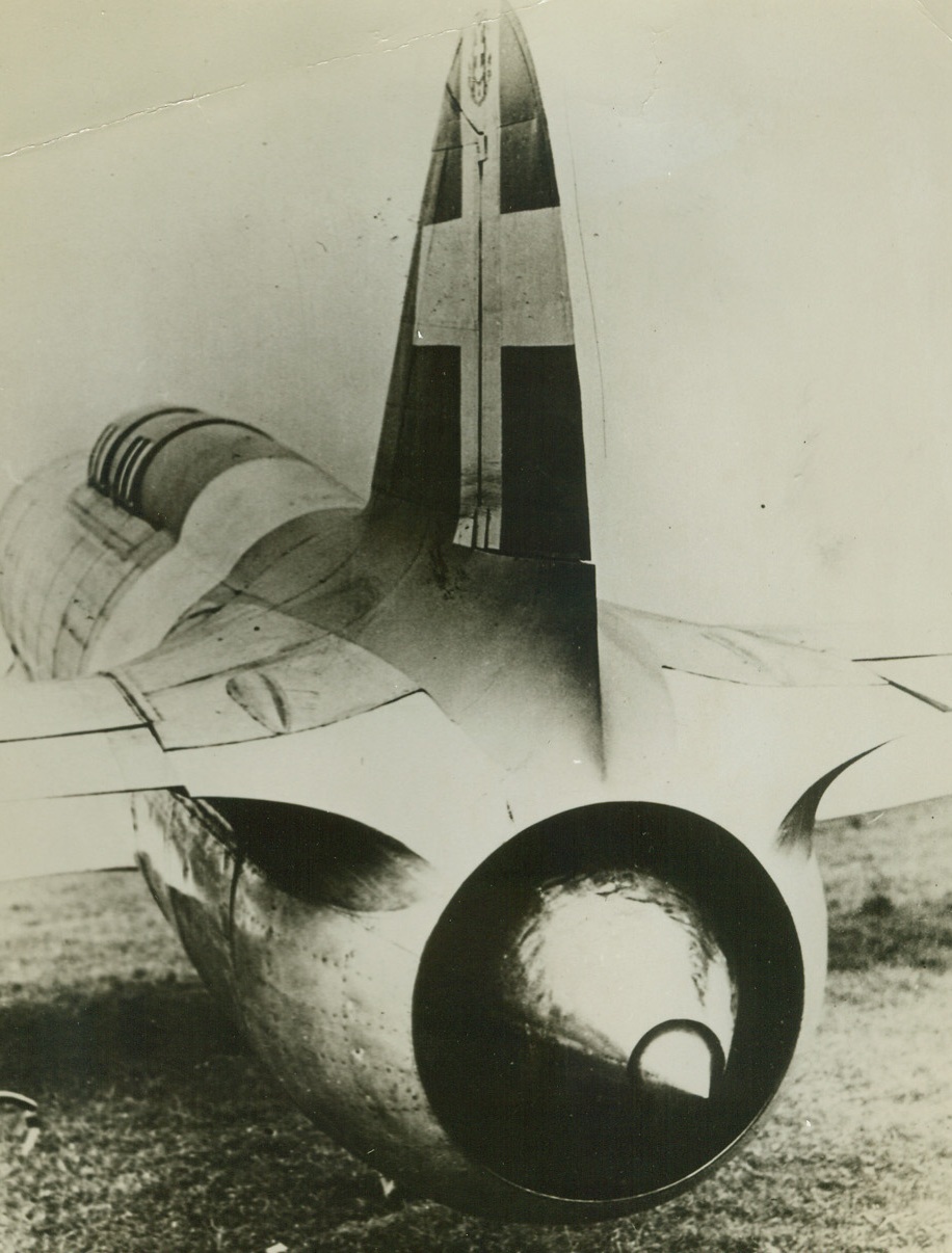 ITALIANS TEST JET-PROPELLED PLANE, 3/29/1942. The photo shows a rear view of a jet-propelled plane being tested by Italian aviation engineers. It is a two-seated, enclosed cockpit, low-wing monoplane with a large single fin and rudder and retractable undercarriage. Weighing about 11,000 lbs., its principle of operation is simple. Air enters a circular duct in the nose is expanded and passed into a compressor, which may be a normal aero-motor or an internal combustion turbine. The air is then ejected through a smaller duct with a controlled outlet behind the plane’s tail. The hot exhaust gases of the motor which drive the compressor are ejected in the same duct. The propulsive force is in the kinetic energy in the jet of air. In tests, the plane has flown comparatively slowly, about 130 M.P.H. However, no effort has been made to reach a high speed. Known as the Carroni-Campini, the plane was first tested in August of 1940. The model shown here is a later one, and improved. Credit Line (ACME);