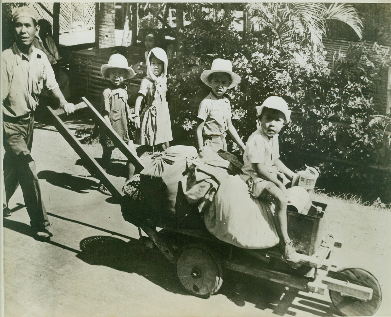 FIRST PHOTOS OF JAP ATTACK ON PHILIPPINES, 3/30/1942. This picture released on March 30th is one of the first brought out of the Philippines since the start of hostilities. It was rushed from Australia to the Capital for release by the Pictorial Branch of the War Department, Bureau of Public Relations. Photo shows residents of Cavite evacuating after the Jap bomb raid of December 10th, 1941. Credit: U.S. Army photo from Acme.;