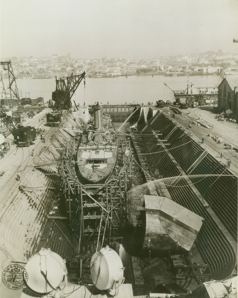 USS SHAW TAKE A BOW, 3/9/1942. AT A PACIFIC COAST NAVY YARD – The Destroyer USS Shaw is whole once again. The long, lean “sea greyhound” is shown in drydock with a new forward section to replace the temporary snub bow (right foreground) which was fitted to the vessel after damage suffered in the Japanese attack on Pearl Harbor on Dec. 7. The Destroyer arrived here under her own power. Credit: U.S. Navy photo via OWI Radiophoto from ACME;