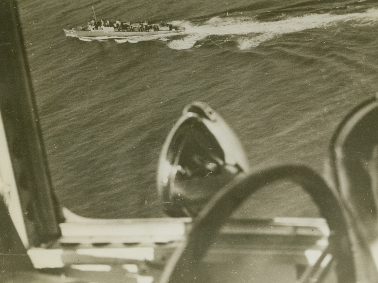 Destroyer at Work, 3/14/1942. A Navy blimp on coastal patrol is an interesting bystander as a destroyer flings four depth charges into the sea in a vicinity where two United Nations ships were torpedoed. Photo was made from the blimp during the routine patrol flight. Destroyer let go with the charges after picking up a U-Boat with her listening apparatus. Credit: ACME.;