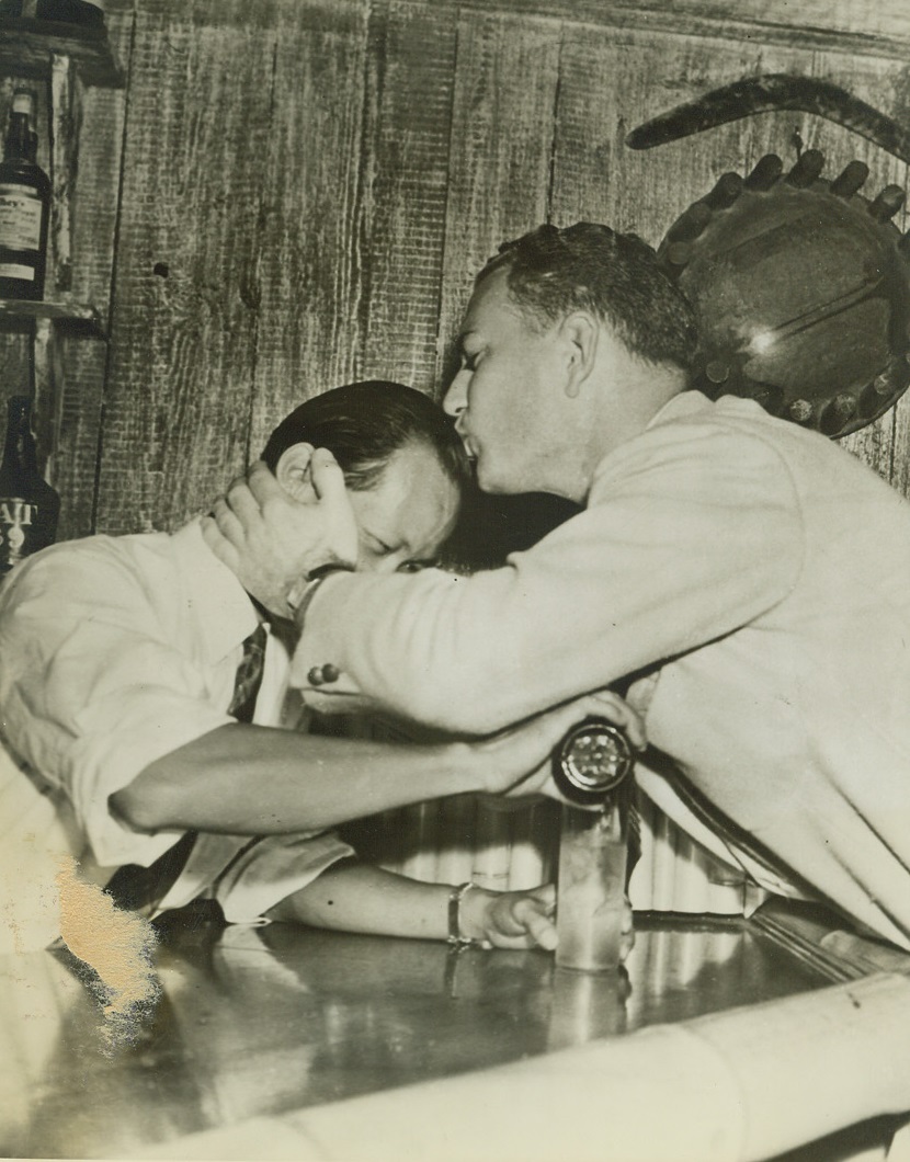 Welcome Home for an Old Friend, 3/8/1942. Honolulu – Overjoyed at the return of the privilege of standing up to a bar and ordering a long, cool one, citizen Walter Clarke plants an appreciative kiss on the head of his favorite bartender as officials allowed the return of liquor for a 30-day probationary period. It hadn’t been allowed since December 7. Credit: ACME;
