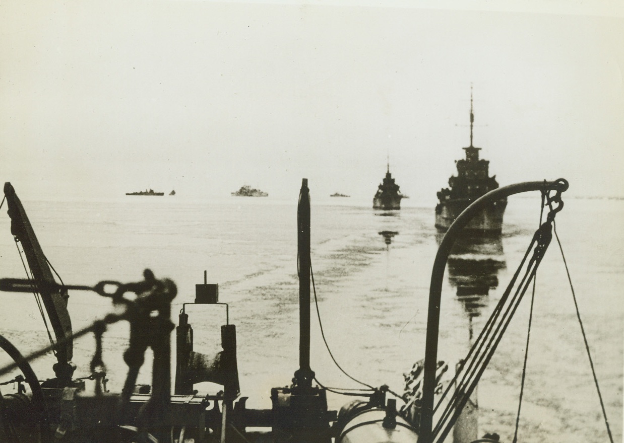 BRITAIN DELIVERS THE GOODS, 3/7/1942. The winter sun of the Arctic breaks through as a British convoy steams cautiously through the ice-crusted waters of the Northern Soviet coast.  Not even the bitter weather of Arctic winter has kept the British ships from getting through to the Soviet Union with their precious cargoes. Credit: Acme;