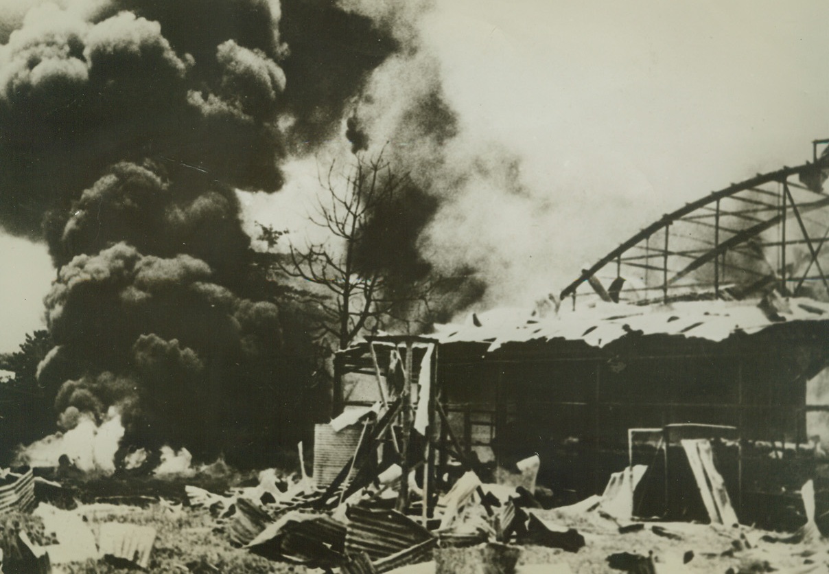 In the Path of Conquest, 4/6/1942. Salamaua, New Guinea --- As the Japanese pat of conquest extends southward to Australian waters, a hangar at Salamaua, New Guinea, burns during a Japanese air raid.  This is one of the first pictures to reach the United States of Japanese destruction on the island. Credit line (ACME);
