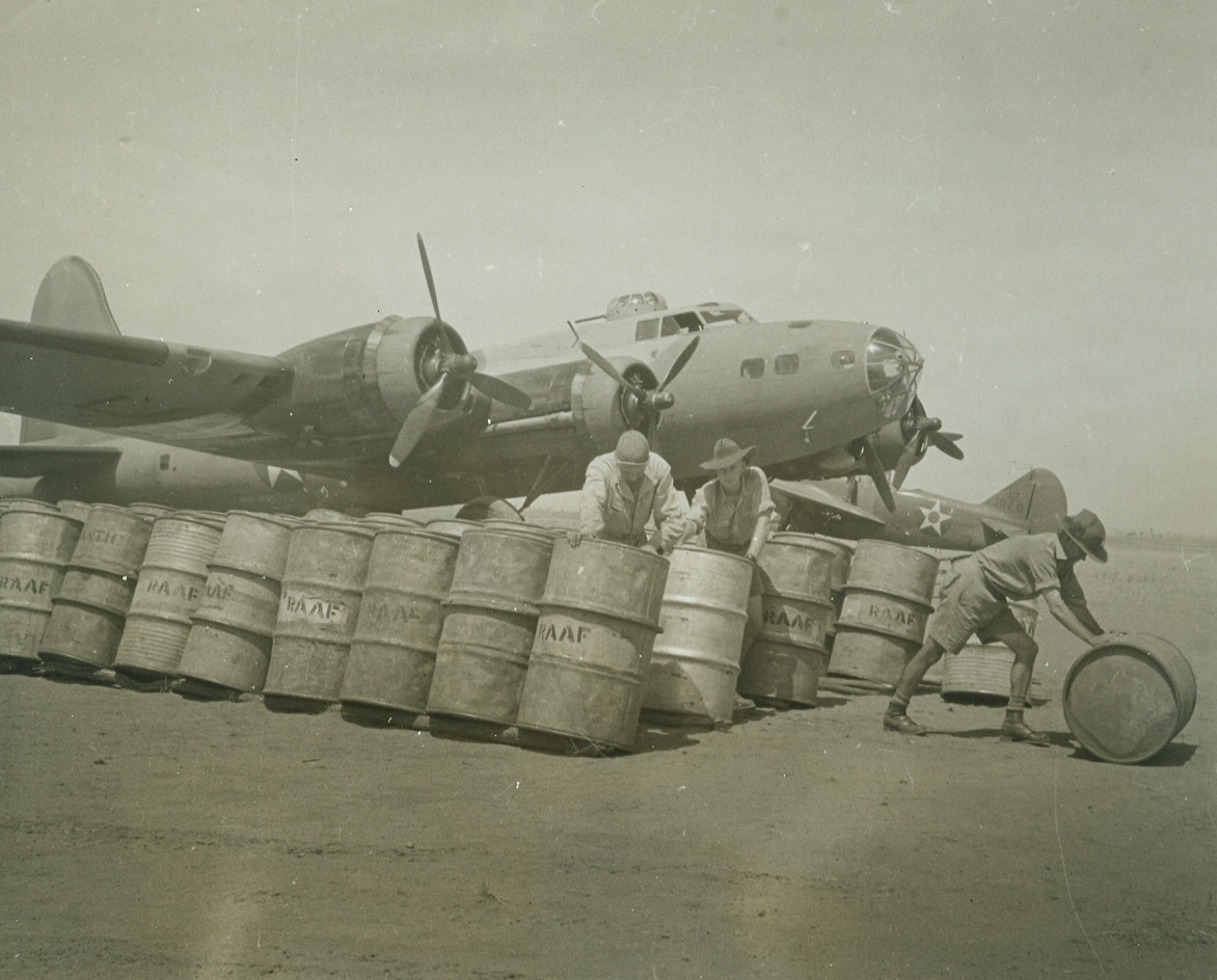 No Rationing Here, 5/12/1942. Australia – Among the first pictures to be received from the interior of Australia, this photo shows American and Australian sokders refueling a huge U.S. Army flying fortress at an undisclosed airdome.Credit Line (ACME);