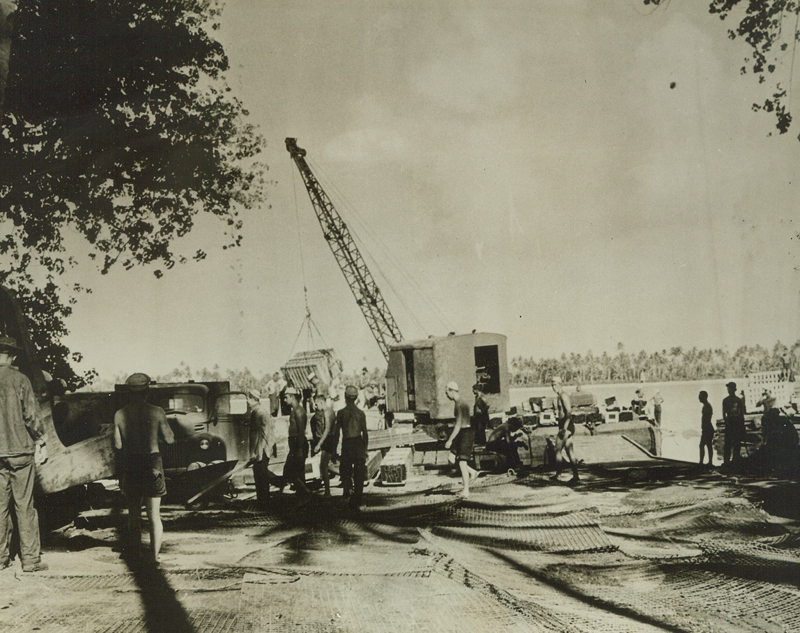 Establecimiento en la isla del Pacífico Sur, 9/6/1942.  Algunas ubicaciones en el sur están mapeadas sin trabajo necesario, suministros y el ejército, la marina y el Cuerpo de Marines de Mama Sam para establecer una nueva base en la isla del Pacífico Sur.  Se ilustra esta serie de fotografías divulgadas por la Marina.  Arriba, ingenieros militares y navales colocan esteras de alambre para que el equipo pesado utilizado para instalar la cabeza de playa no se hunda en la arena.  Crédito: Foto oficial de la Marina de los EE. UU. De ACME;