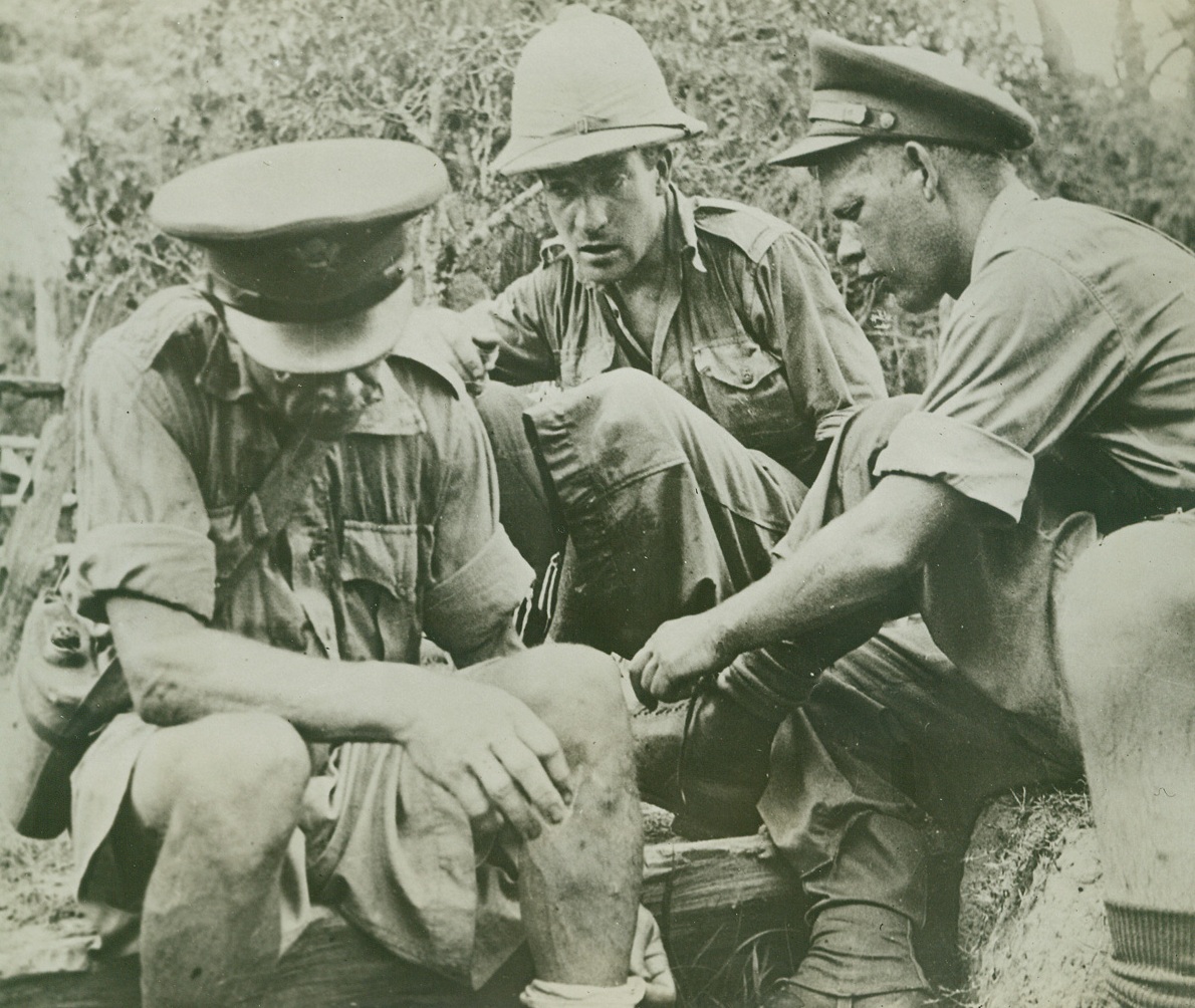 Retreat from Burma, 7/30/1942. On one of the most dramatic journeys recorded in the animals of the war, so far, Lt. Gen. Joseph W. Stillwell, at the head of a band of 114 Americans, Burmese nurses, Chinese, Indians, Britons and Anglo-Indians, covered 140 grueling miles on their retreat from Wuntho, Burma, which began on May 4th, 1942.  For days the band struggled through the torturous heat of the dense Malaria-infested swamps and jungles of Burma, to reach the banks of the Uyu river, where they were forced to abandon the few jeeps and trucks they had.  To proceed on home-made rafts, down the river to the Chindwin and thence to Imphal on the Indian frontier.  They arrived at their destination, Dinjan, India, with only a few cases of Malaria and heat exhaustion.  Considering what they had been through, their journey was remarkably successful.  Here, in a series of 25 official U.S. Army photos, just arrived from India, the story of the retreat is graphically presented. New York Bureau Maj. Gordon S. Seagrave (left), Capt. J.H. Grindlay, (right), and a member of the Friends Ambulance Unit from Burma try to comfort their feet on a rest stop.;
