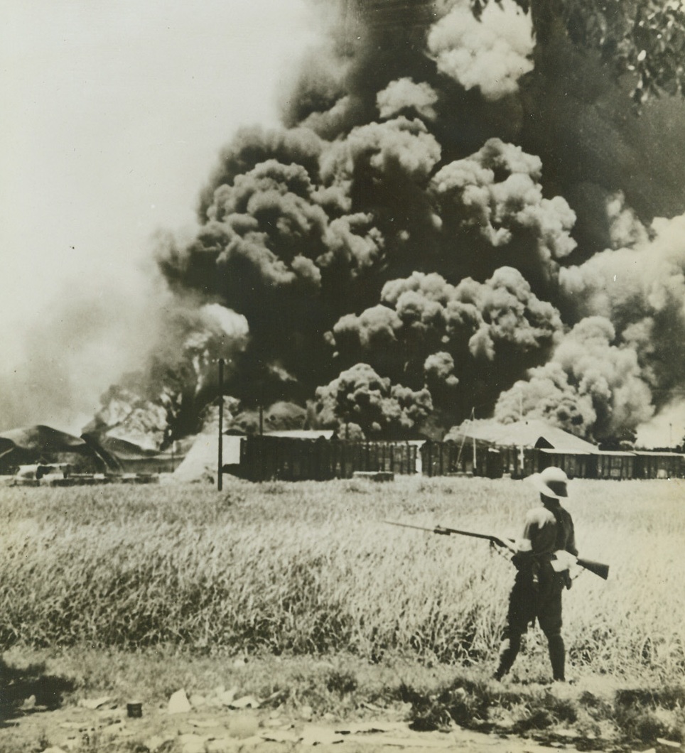 No Title, 8/26/1942. Burning oil tanks and oil cars greeted the Japanese when they occupied the former Dutch-held Tanduong, in Java, according to the Japan Photo Library caption which accompanied this picture. The photo reached the U.S. via Brazil. Credit: ACME.;