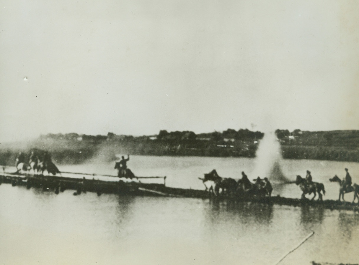 THE COSSACKS FIGHT AT STALINGRAD, 8/30/1942. STALINGRAD, RUSSIA—Under heavy enemy artillery fire, members of a Cossack Cavalry unit cross a causeway over river in the Don Region near Stalingrad. Latest reports from Moscow, Aug. 30, stated that Soviet counter-attacks had smashed the German spearhead before Stalingrad, and also the German attack from the northwest.;