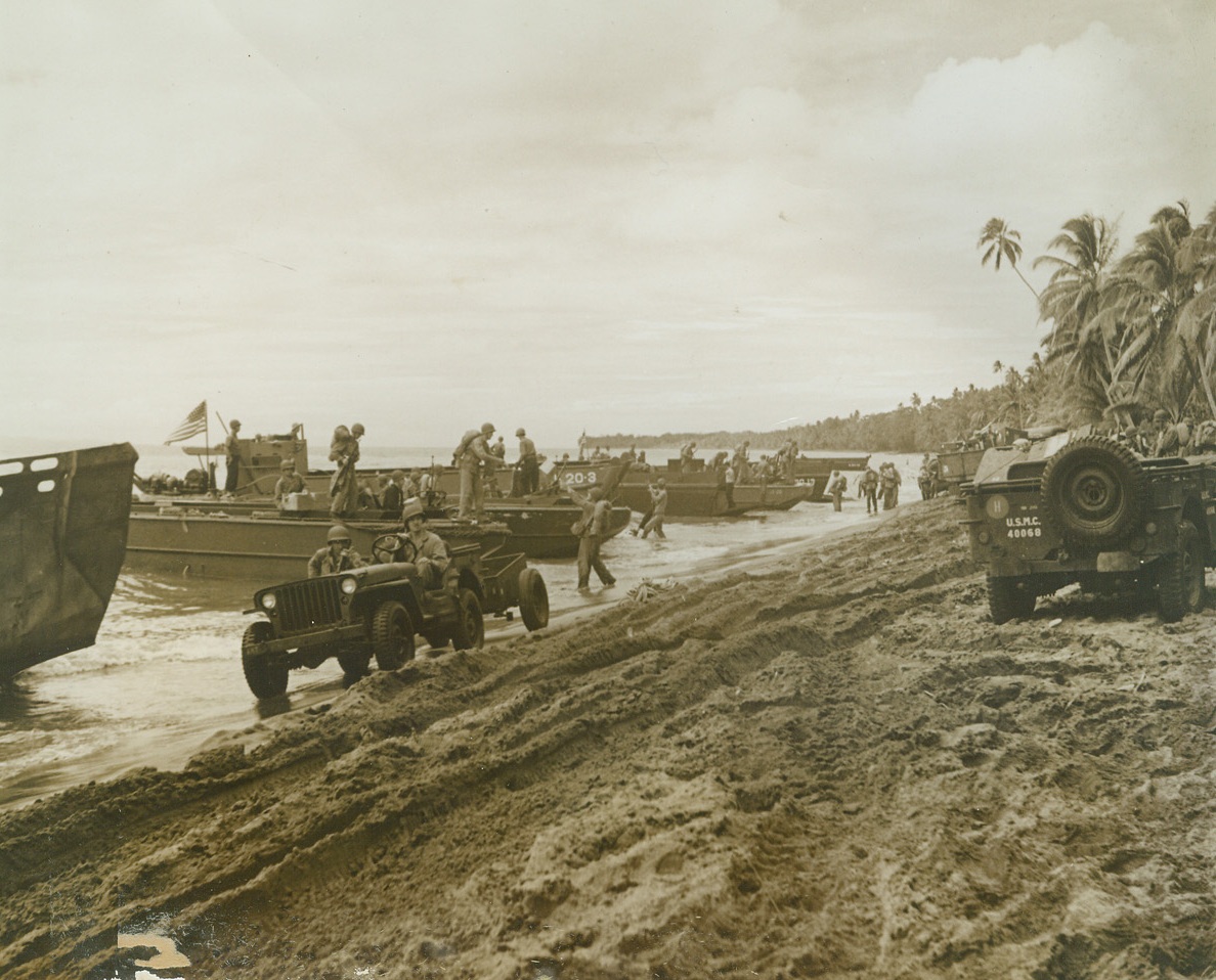 Mechanized Landing in the Solomons, 8/30/1942. Solomon Islands – Jeeps and new-type landing barges line the sandy beach of Guadalcanal island as U.S. Marines and to launch their offensive against the Japs in the Solomons.  Photo, released in Washington yesterday, was made by War correspondent photographer Sherman Montrose of ACME News pictures. Credit line (ACME);