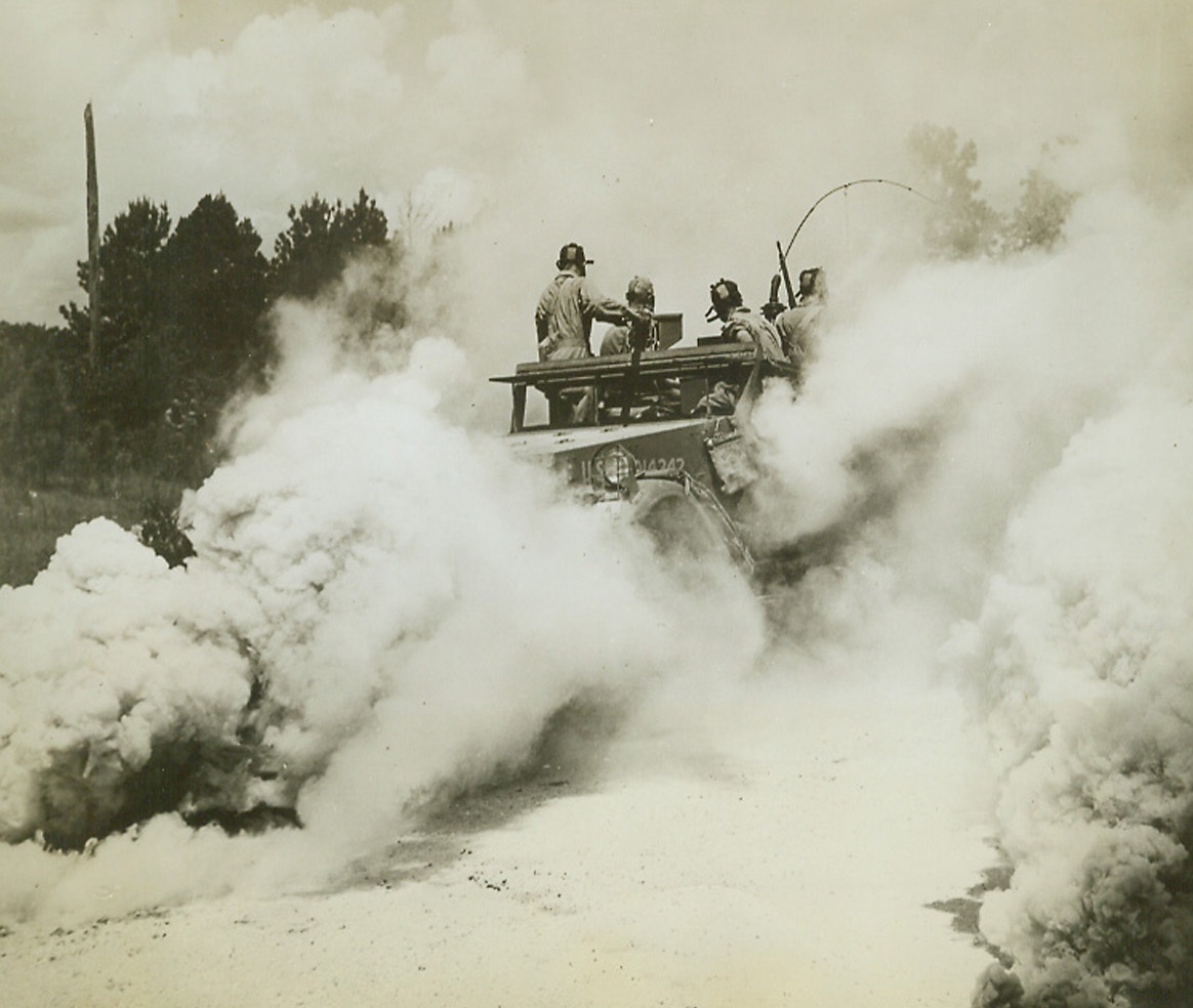 Smoky Refuge, 8/27/1942. This half-track is enveloped in a smoke screen as its crew concentrates on attack from the rear while solving one of the problems of the Third Army Louisiana Maneuvers.Credit: U.S.A. Signal Corps photo from ACME.;