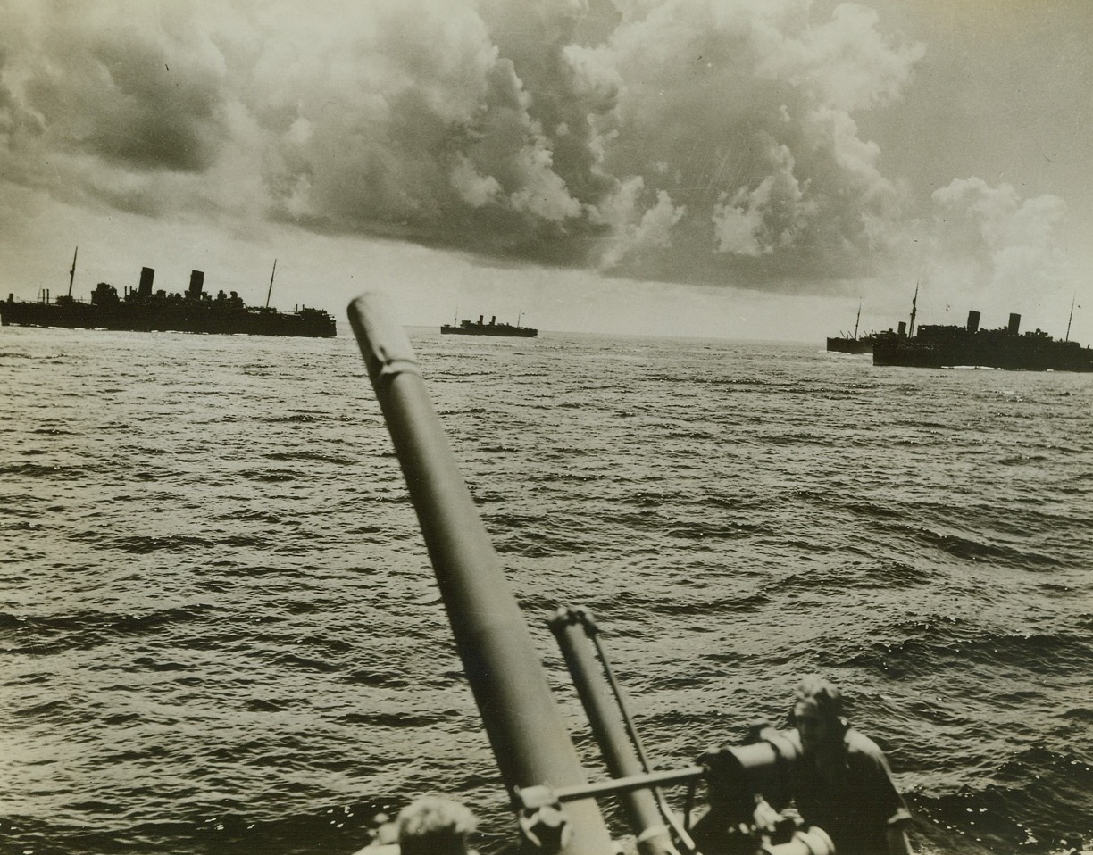 READY FOR RAIDERS, 8/3/1942. The crew of a gun on a transport, part of a convoy bound for England, as they keep on constant watch for enemy raiders.  Other ships of the United Nations convoy can be seen in the background.Credit: Acme;