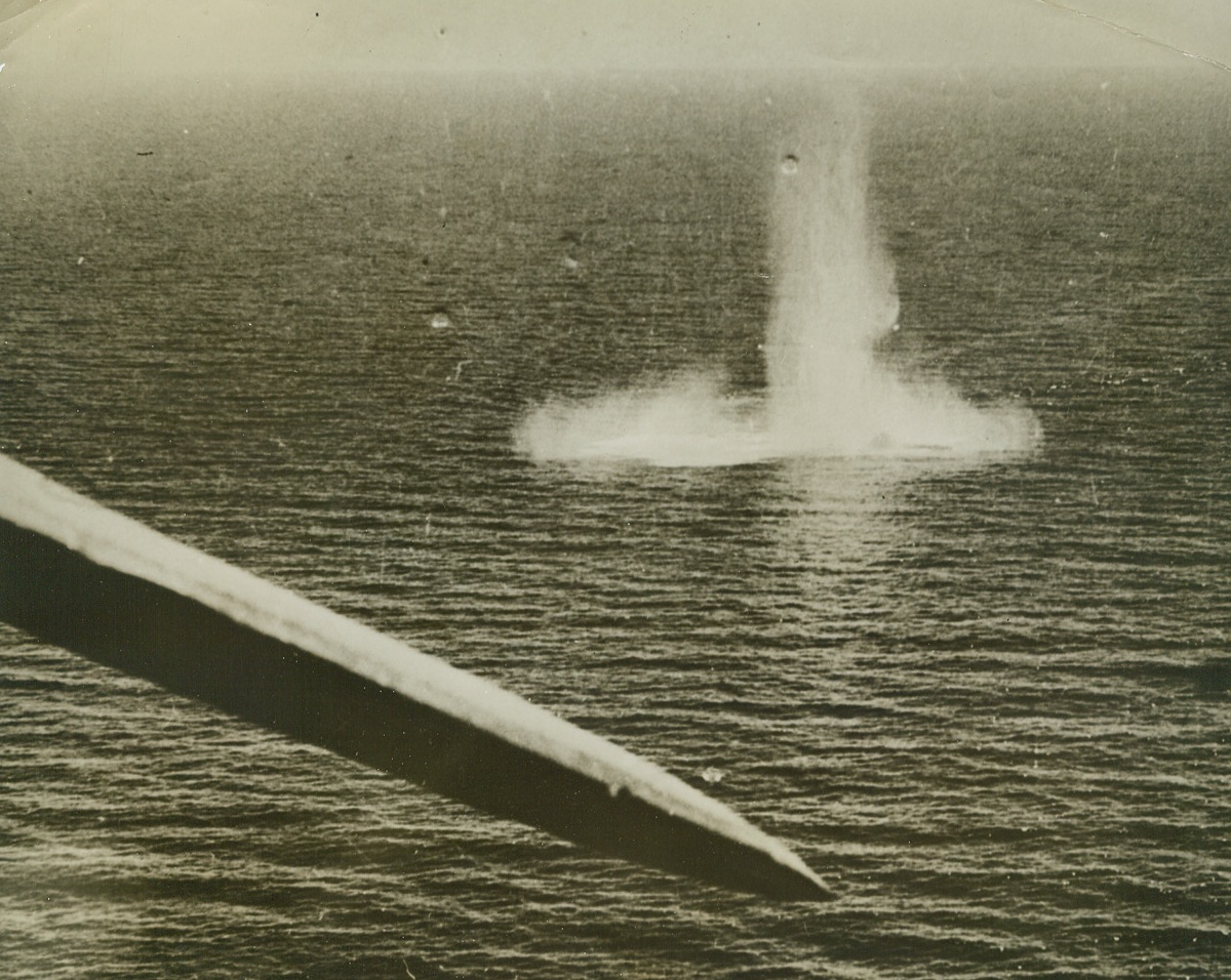 BOMBING OF AN ITALIAN SUBMARINE, 8/26/1942. MEDITERRANEAN—As the upheaval from a stick of bombs dropped by a Sunderland plane subsides, the object of the attack—an Italian submarine caught on the surface of the Western Mediterranean—can just barely be seen. The pilot of the Sunderland sighted the sub while on Coastal patrol in the Western Mediterranean, and reported that his bombs severely damaged the outer casing of the undersea craft. Credit: Acme.;