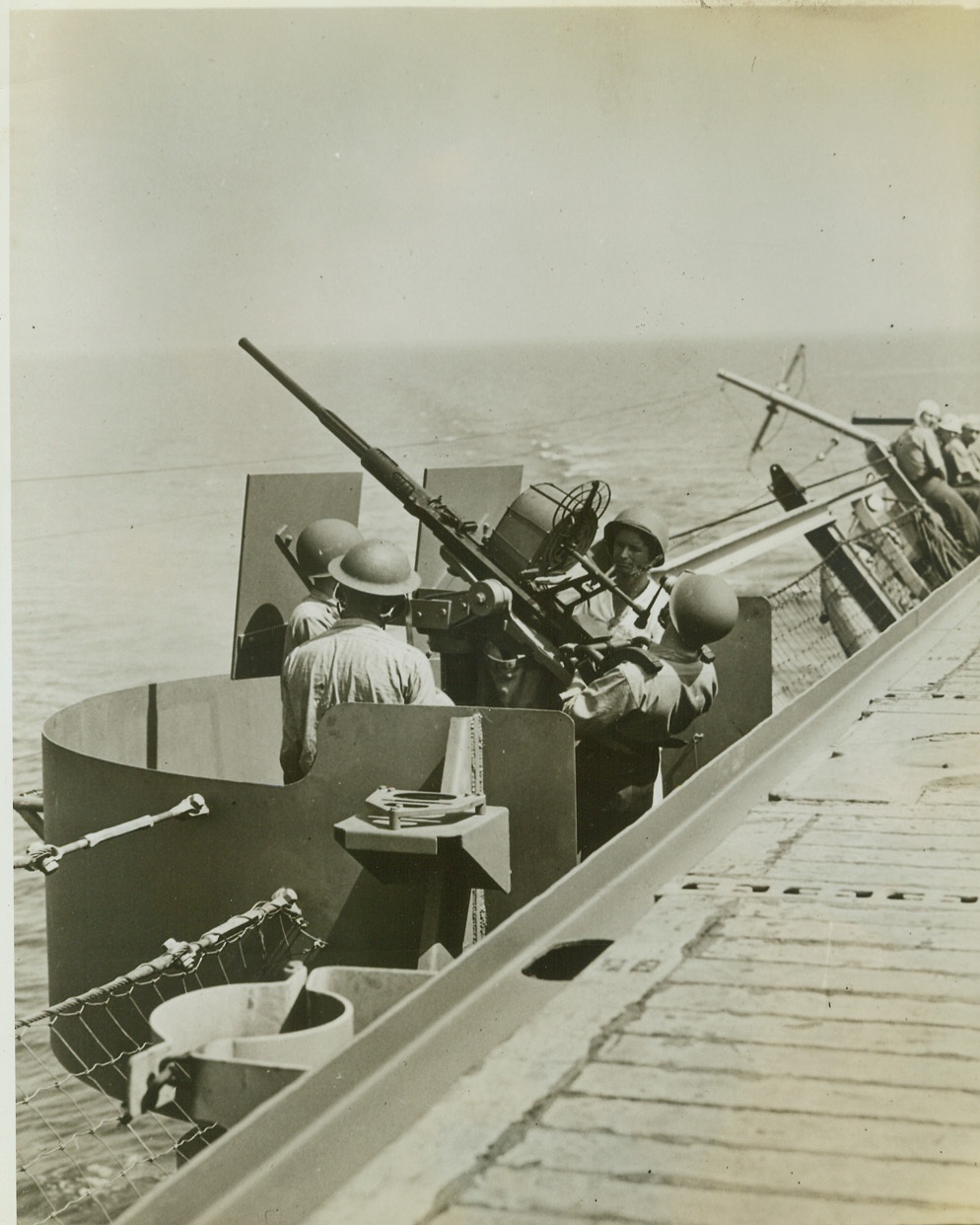 Tense Moment on a U.S. Tanker in a Convoy, 8/4/1942. Life-jacketed U.S. sailors leap to their guns as a submarine alarm is sounded on a naval tanker in a convoy somewhere in the Indian ocean. Credit line (ACME);