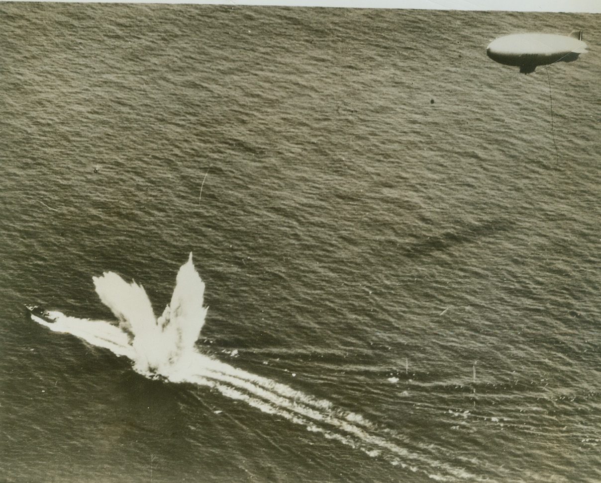 Bad Sign for U-Boats, 8/4/1942. Here's how air and sea vessels are cooperating to put the blast on U-boats operating off Uncle Sam's shores. A U.S. Navy blimp signals a nearby Coast Guard "sub-buster" to a spot where an enemy submersible is suspected of lurking in the Atlantic. The cutter streaks across the area, laying an "egg" that sends columns of water streaking skyward in a V for victory. After that the U-boat lurks no longer.  Credit: (ACME);
