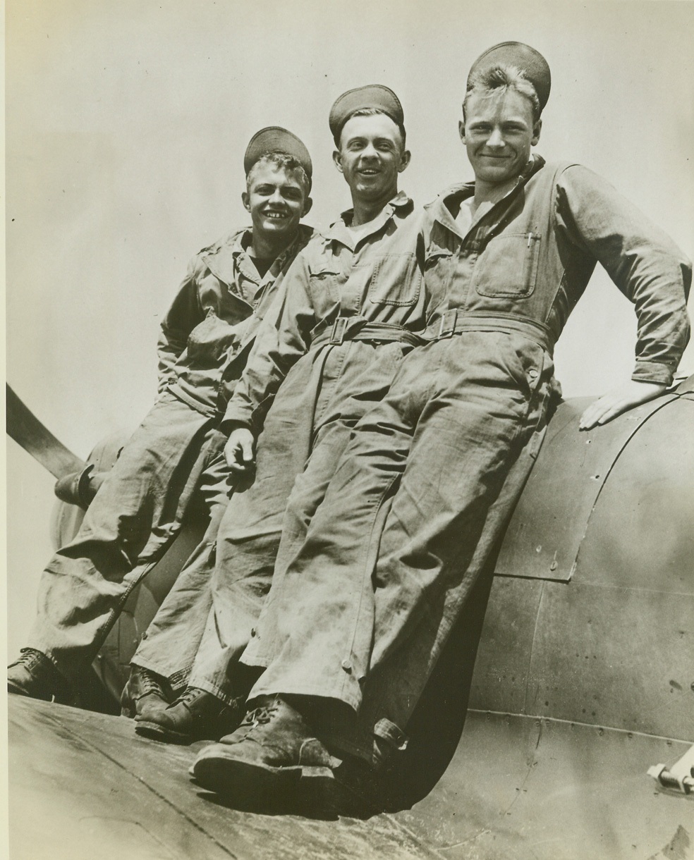”AMERICANS ARE CONFIDENT—”, 8/5/1942. SOUTHERN ENGLAND – With smiles of confidence in ultimate victory, these young American members of a U.S. Army Air Force ground crew at a station in southern England pose for the photographer. It’s upon the willingness and capability of “greasemonkeys” like these that the success of any Air Force venture depends. They are (left to right): Don Walker, of Washington, Iowa; Mallie Galloway, of Darlington, S.C.; and John Perkins, of Woodruff, Wisconsin. (Passed by censors). Credit: ACME;