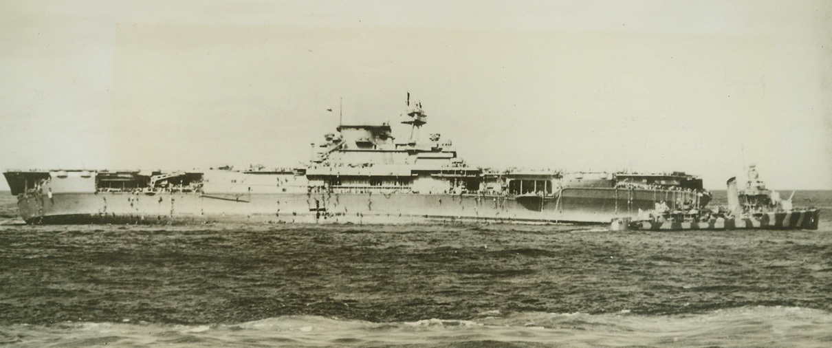 ABANDON SHIP!, 9/16/1942. WASHINGTON, D.C.—Crewmen slide down ropes over the side of the aircraft carrier U.S.S. Yorktown to swim to the escort vessels that stood by to rescue the men, after the order to abandon ship had been given. Few of the 2,072 officers and men the ship had as a normal complement were lost during the abandonment. After undergoing punishing bomb and torpedo hits on June 4th, the ship was still afloat and it was thought that it might be salvaged, but two more torpedoed from a Jap sub finally finished off the vessel on June 7th. Photos and story were released by the Navy, Sept. 16th.  Credit: OFFICIAL U.S. NAVY PHOTO FROM ACME.;