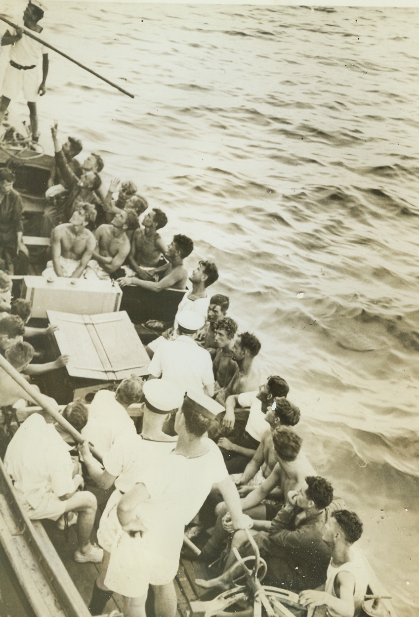 Rescue of Survivors from H.M.S. Dorsetshire”, 9/8/1942. Indian Ocean – As if they were going along “just for the ride”, these courageous survivors of H.M.S. Dorsetshire sit quietly in a lifeboat while crew members make fast to the side of a British Destroyer which hurried to the scene of action.  With another British cruiser, H.M.S. Dorsetshire was sunk during action in the Indian Ocean, but hundreds of the British tars were saved by prompt action on the part of rescuers. Credit line (ACME);