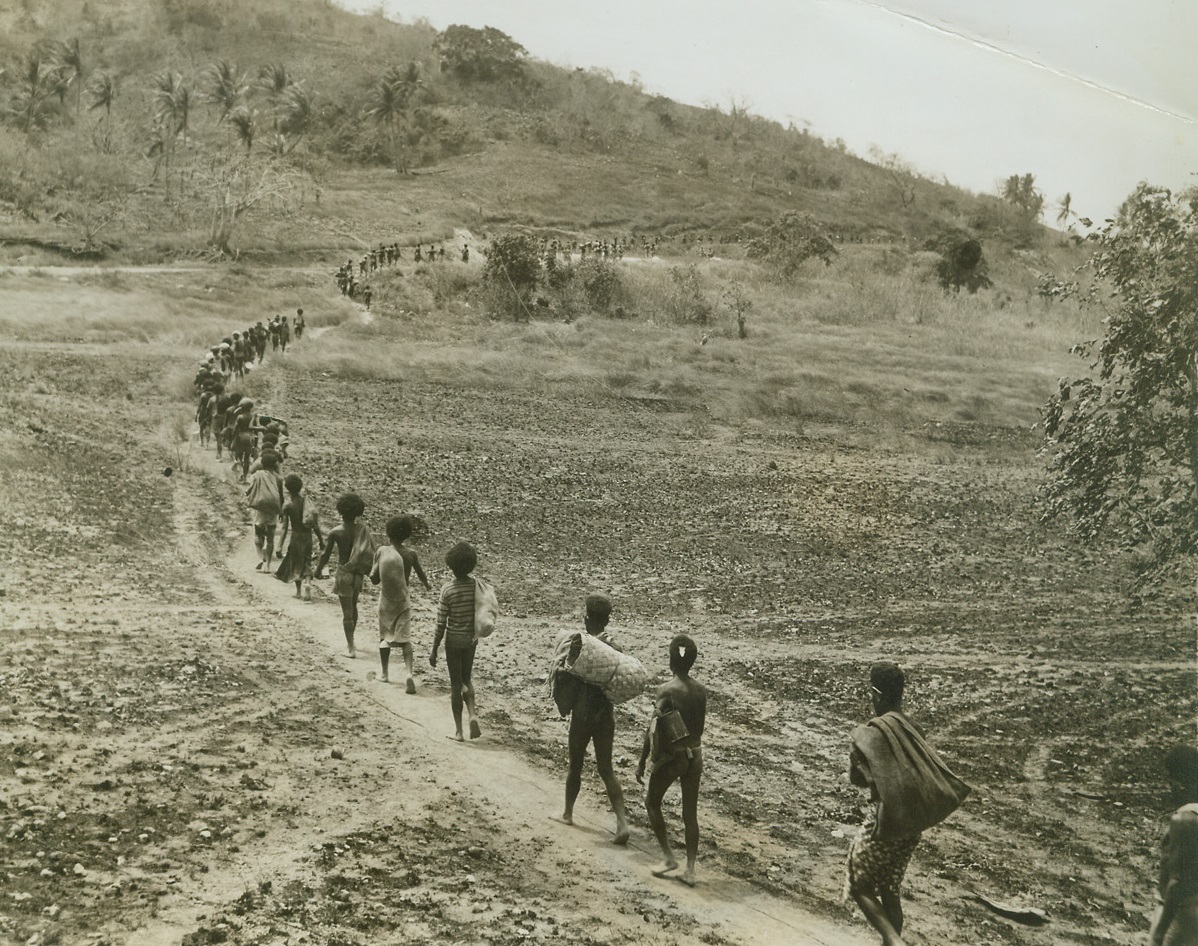 Supplies on the March, 9/17/1942. New Guinea – Each New Guinea native shoulders about forty pounds of supplies, as they make their way on foot to the interior of New Guinea where allied troops are holding off a heavy Jap push toward port Moresby, main allied base. Credit line (ACME);