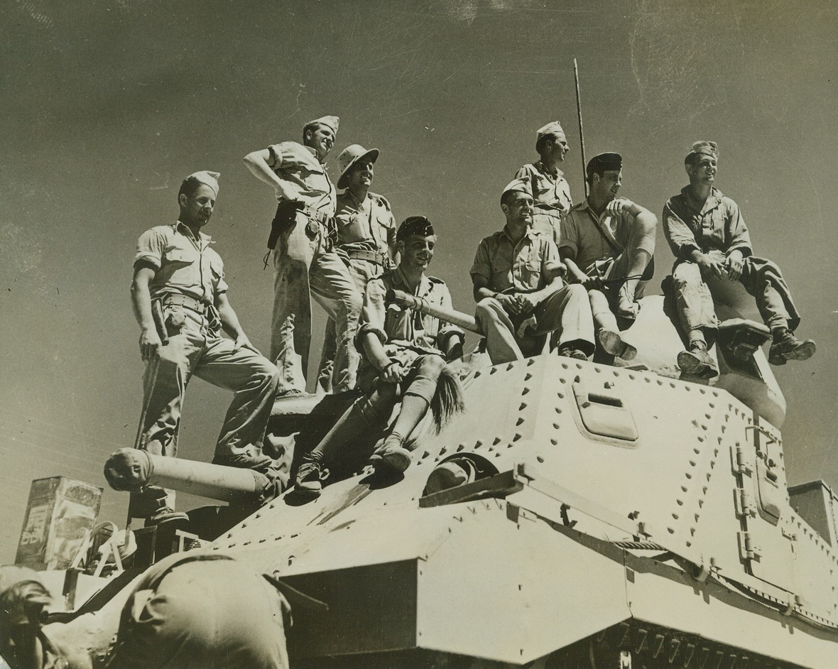 U.S. and British Tankmen in the Desert, 9/11/1942. Egypt – A group of American and British tankists take a breathing spell atop a U.S. – built tank in the Egyptian desert, where the Yank tank crews have been practicing behind the lines to acclimate themselves to the desert heat and to familiarize themselves with methods of desert warfare.  The two lads in black overseas caps are Britishers.  Their behind-the-lines days over, some of the U.S. crews have recently been reported in action against Rommel’s Africa Korps – and doing pretty well for themselves, too. Credit line (ACME);