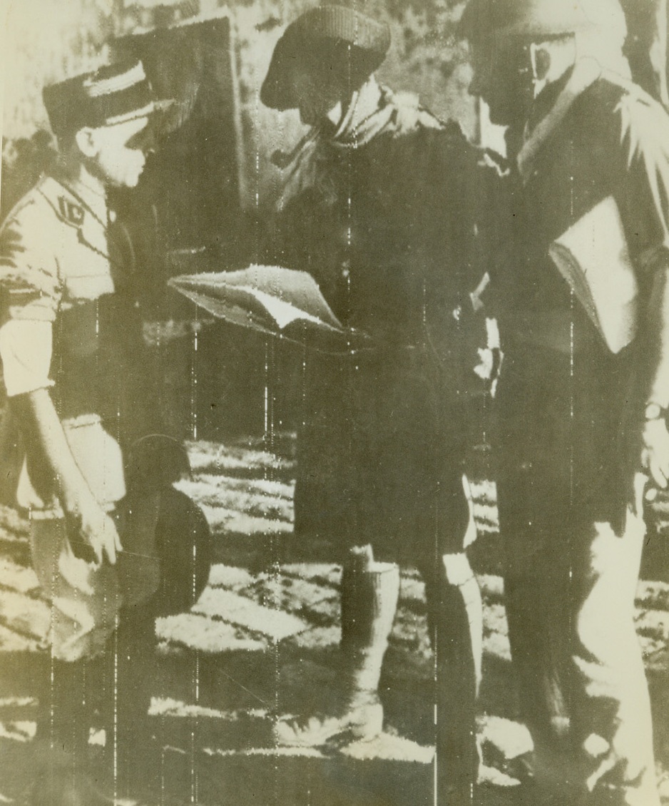 At Capture of Majunga, 9/29/1942. This photo flashed by radio from Cairo to New York, Sept. 29, shows British officers, (right and center) as they interview the French Commandant, Chef De Battalion Martin, at Majunga, after the capture of that strategic Madagascar port, Sept 10. Credit line (ACME radio photo);