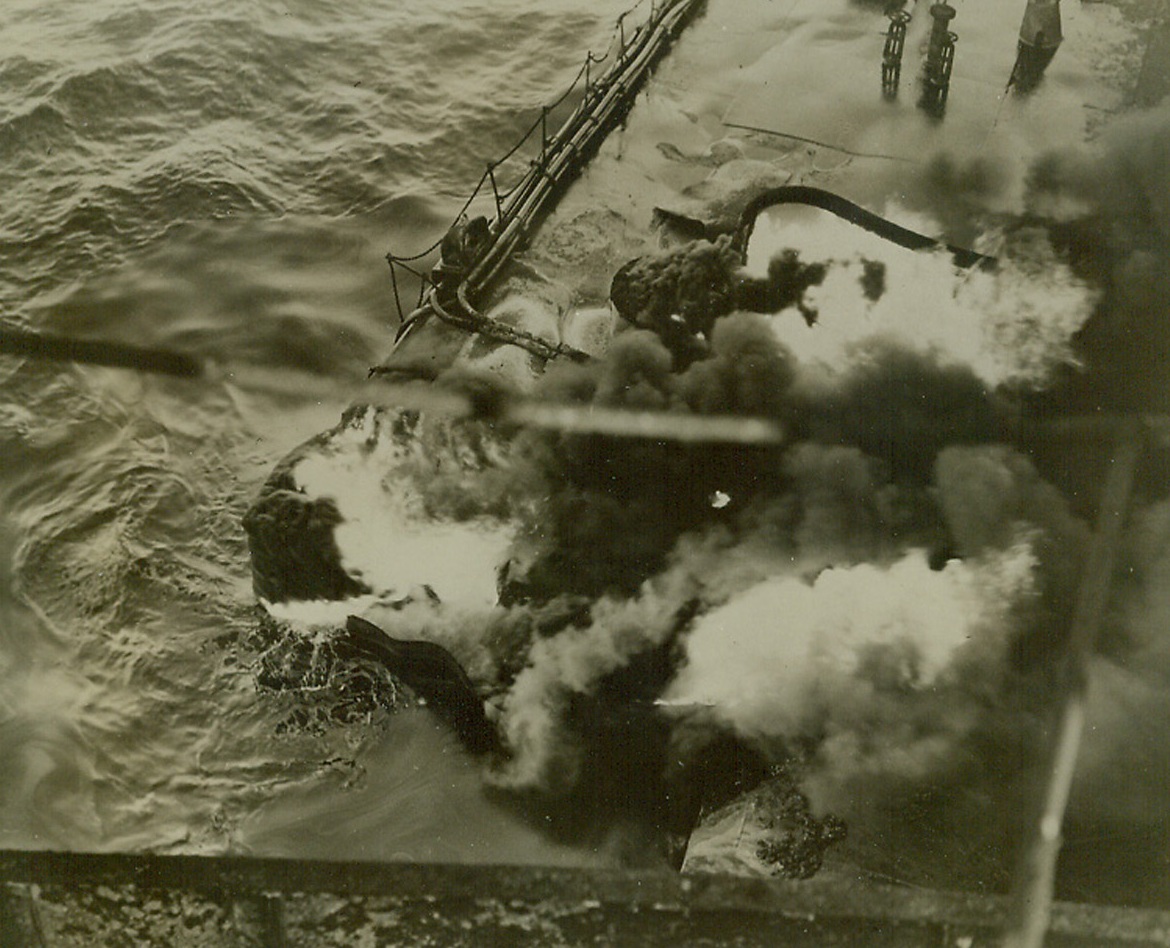Saga of the Atlantic, 9/28/1942. Somewhere in the Atlantic—Flames still rage around the gaping hole torn by the torpedo when it struck a tanker approximately amidships on the portside as oil in the foreground sluggishly moves out into the ocean. Despite a raging fire which sent columns of smoke billowing into the sky, crew members were able to bring the flames under control and the tanker was towed to port by a U.S. Naval ship. The tanker is now in an east coast ship yards under repair and it will soon see service again against its enemies.  Credit: Official U.S. Navy photo from ACME.;