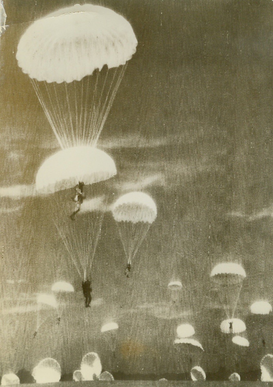 Dress Rehearsal, 9/18/1942. England—During mass invasion exercises in Britain, U.S. parachute troops float down from the skies from operational altitude. Although these troops have been in England for some time, their presence was only made known September 18th from the headquarters of Lt. Gen. Dwight D. Eisenhower, commander-in-chief of the A.E.F. in Europe. Credit: ACME.;