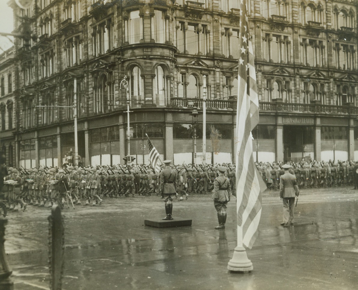 “Tanks For Attack” Parade In Belfast, 9/18/1942. Northern Ireland – American troops pass the saluting base during the “Tanks for Attack” Campaign Parade in Belfast, which was organized by the Belfast War Savings Council so that Belfast savers could have the name of their city on 25 heavy tanks to be built from proceeds of the campaign. British troops took part in the opening parade together with American troops stationed in Northern Ireland. (Passed by Censor) Credit: ACME;