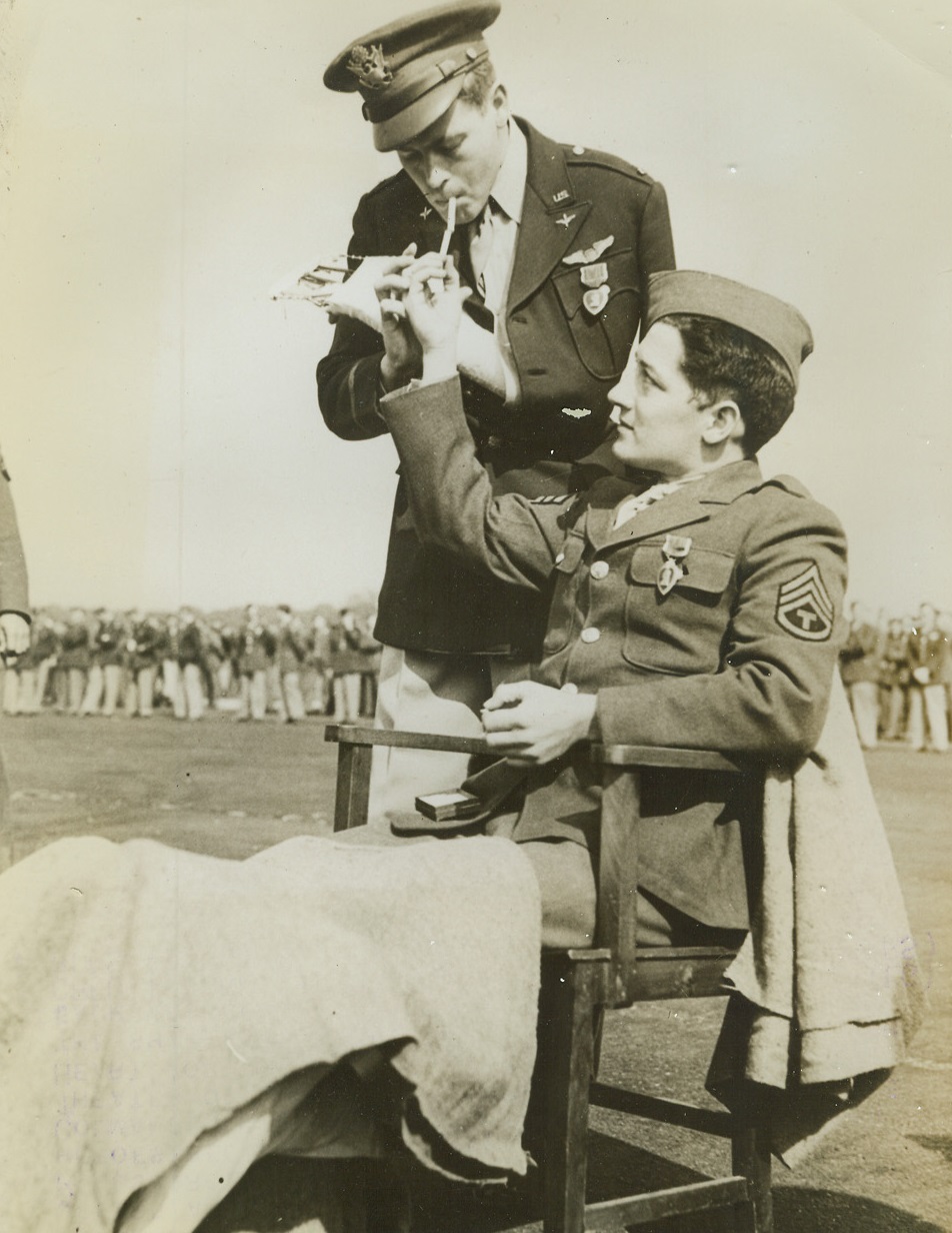 Heroes Both, 9/17/1942. England – Sgt. Frederick J. Rich, of Erie, PA; offers a light to Lt. Eugene M. Lockhart, of Hillsboro, S.C., after ceremonies at which both heroes received from Maj. Gen. Carl Spaatz, Commander of U.S. Army Air Forces in European Theater of Operations, the Order of the Purple Heart for their part in a daylight attack on the shipyards at Le Trait, France during which each was wounded. (Passed by Censors) Credit: ACME;