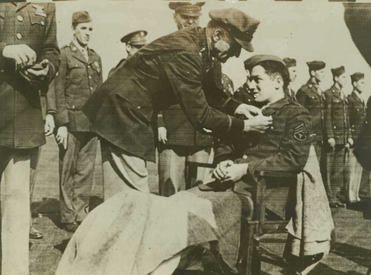 Gen. Spaatz Decorated Wounded Airman, 9/17/1942. England – Maj. Gen. Carl M. Spaatz, Chief of the U.S. Army Air Force in Europe, pins the Purple Heart on Sgt. Frederick J. Rich of Erie, PA at an Air Field somewhere in England in recognition of his “extraordinary valor” in action against the enemy over Europe. Sergeant Rich was wounded while taking part in a daylight bombing of shipyards in Le Trait, France by U.S. Flying Fortresses. Photo was cabled to New York from London today. Credit: ACME Cablephoto;