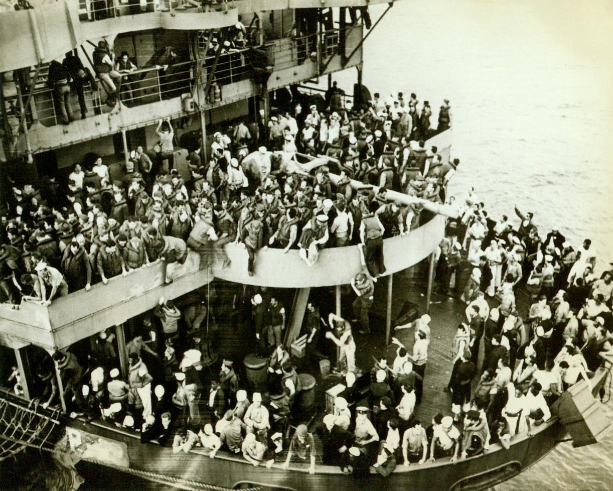 Passengers On Wakefield Awaiting Rescue, 9/9/1942. Washington, D.C. -- Passengers and crewmen wait calmly on the stern decks of the burning U.S. Transport Wakefield-- Formerly the luxury liner S.S. Manhattan -- As the cruiser from which this photo was taken nears to take them off. Warships that came to the rescue of passengers on The Wakefield, on which fire broke out Sept 3, saved approximately 1600 persons. The vessel has been salvaged and is now in an Atlantic port. 9/9/42 (ACME);