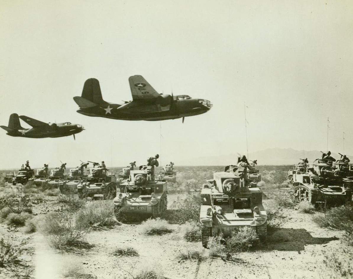 Grim Rehearsal In The Desert, 9/24/1942. Far out on the Badlands of California’s deserts, Air and Armored Forces of the U.S. Army are engaged in grim rehearsal for the day when they will meet the battle-wise and merciless forces of the Axis Powers. Soldiers are learning tough living, and tough fighting tactics. Here, light tanks of the armored forces have met with attack bombers of the ground-air support command, which represent the “enemy”. Every machine gun on the tanks is bearing on the planes, while gunners in the planes are ready to “strafe” the tanks when they can bring their guns to bear. 9/24/42 (U.S. Army Photo From ACME);
