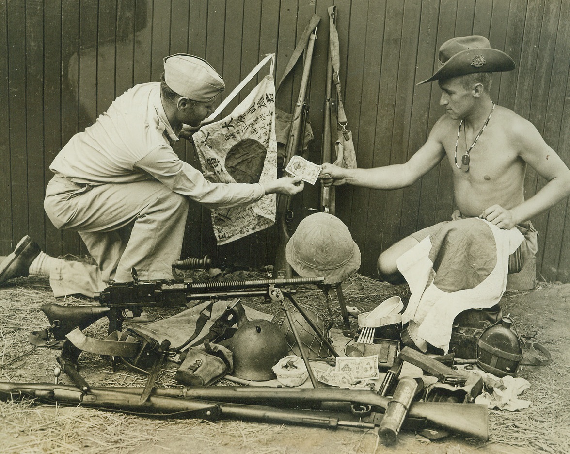 Jap War Trophies in New Guinea, 9/15/1942. New Guinea - - An American and an Australian solder, “somewhere in New Guinea”, are pictured as they examine some Japanese arms and other war equipment that were captured by allied forces during their operations against the Nipponese.Credit Line (ACME);
