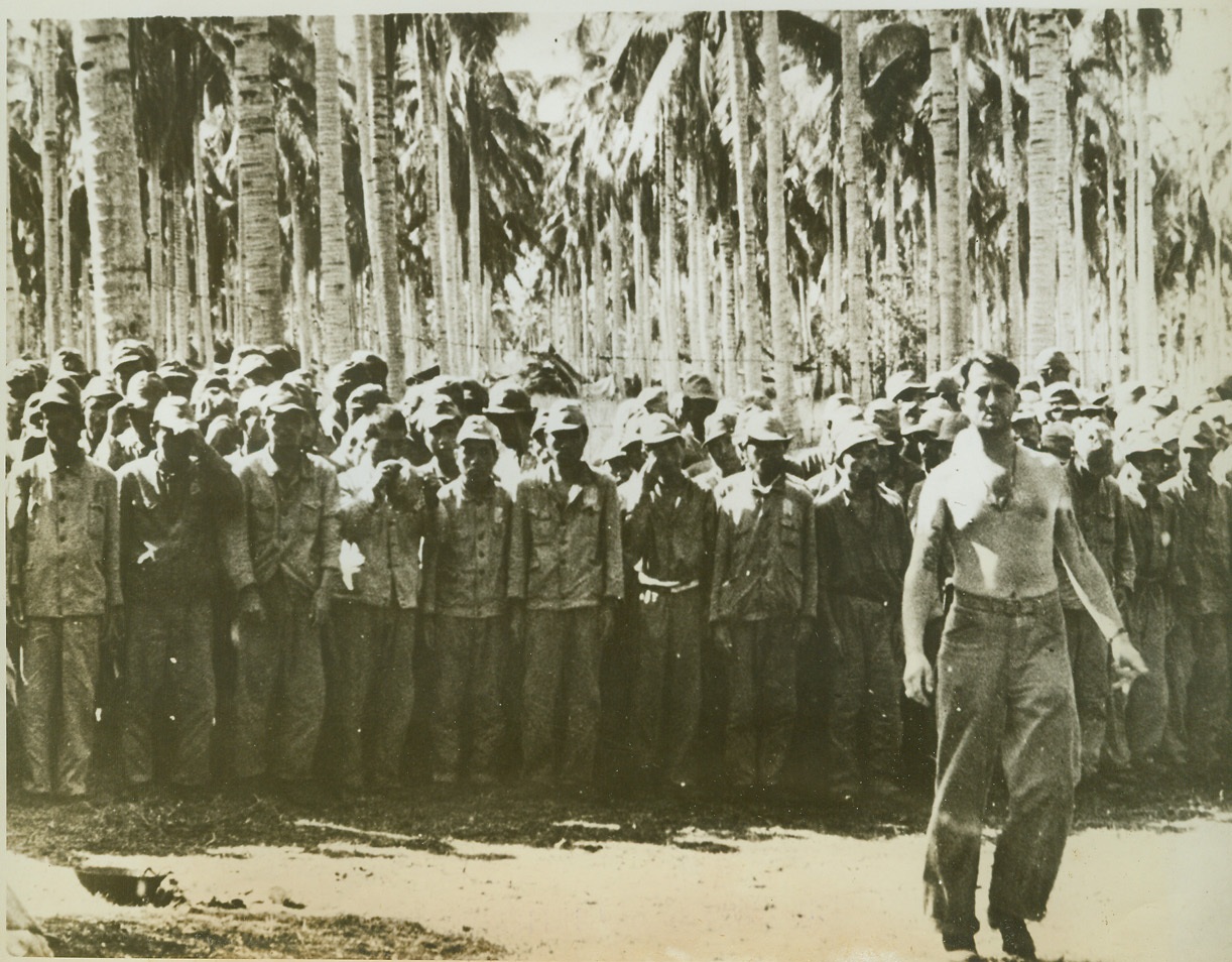 JAPS CAUGHT BY U.S. MARINES, 9/22/1942. GUADALCANAL, SOLOMON ISLANDS – A crowd of Japanese workers, who were captured by the U.S. Marines during the fighting on Guadalcanal Island recently, line up at a prison camp. The Japs had been building bases and installations on the island. (Passed by censors.) Credit: ACME;