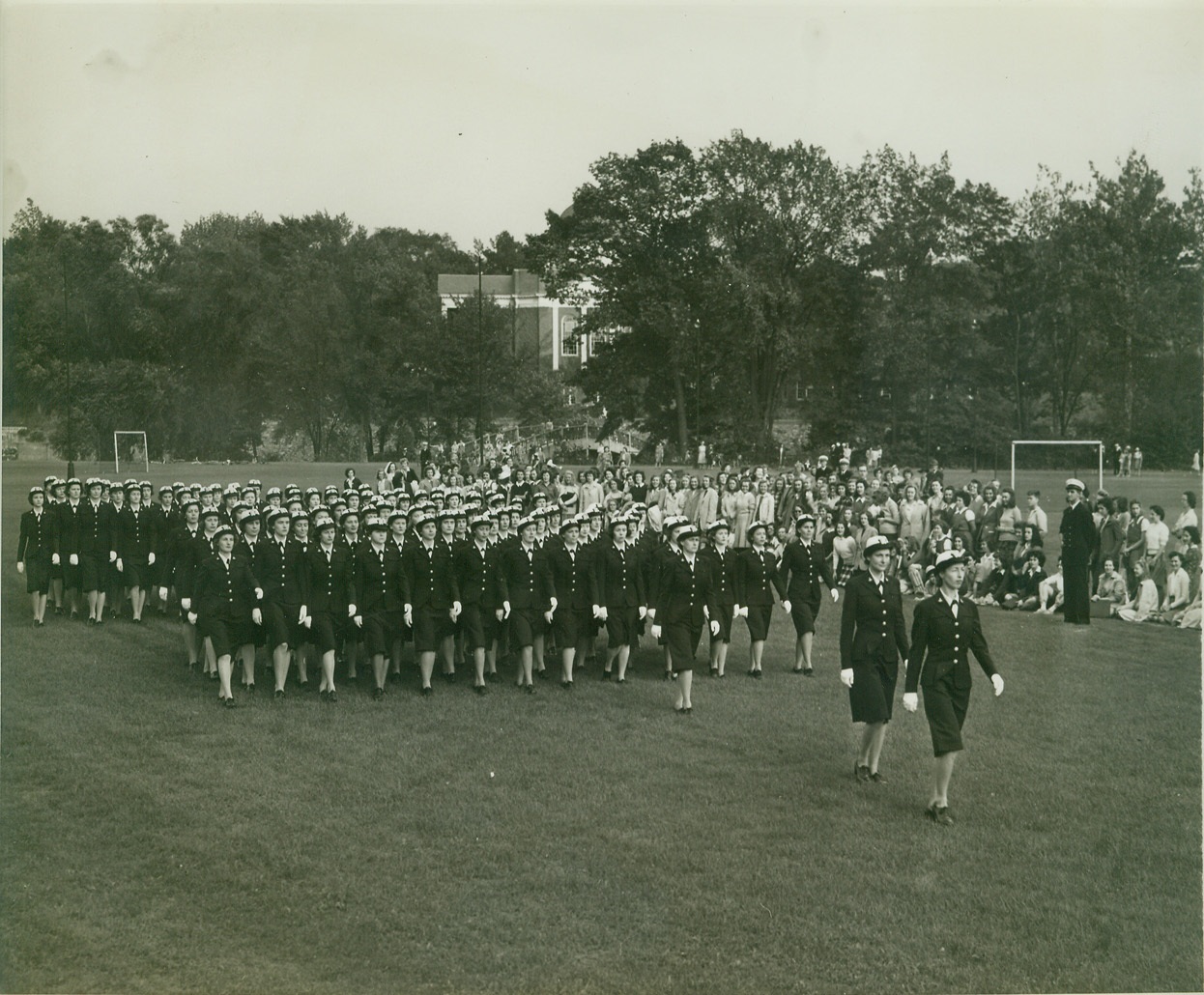THE WAVES ON DRESS PARADE FOR FIRST TIME, 9/24/1942. NORTHAMPTON, MASS. – The WAVES held their first dress parade and review here today on the campus of Smith College. Here, the WAVES hold dress parade as the students of Smith College in the background watch. Credit: OWI Radiophoto from ACME;