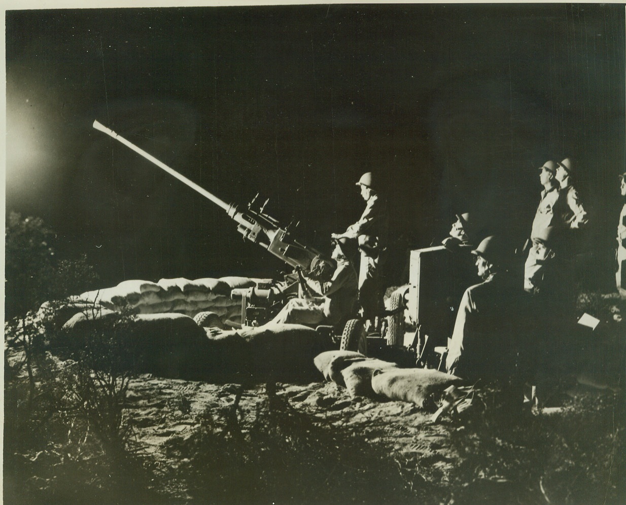 Ready for Night Raiders, 9/29/1942. CALIFORNIA -- A 40-millimeter anti-aircraft gun crew of an anti-aircraft coast artillery unit man their weapon during a night practice demonstration in the California desert. Credit: (ACME);