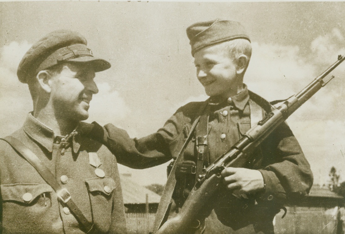 FATHER AND SON FIGHT TOGETHER, 11/22/1944. VILEIKA, U.S.S.R.- A father and son who fight side-by-side with a guerilla band in Russia, A. Volynets and his 13-year-old son, Nikolai, are shown after their recent return to the newly-liberated White Russian town of Vileika. Commander of a guerilla detachment since July, 1941, Volynets considers his young son one of his best scouts. Credit: ACME;