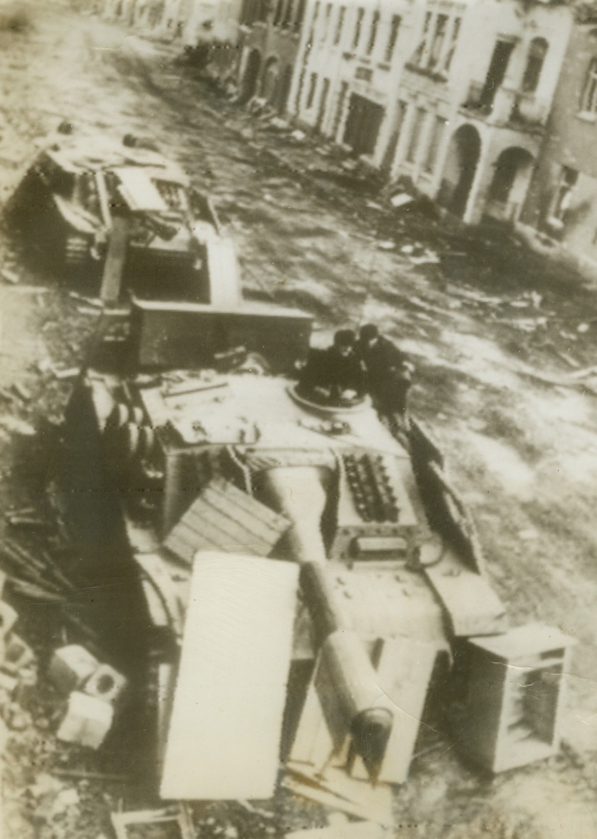 Assault Guns Bark in the Streets, 11/23/1944. WUERSELEN, GERMANY—Ineffectually camouflaged with debris from the shell-wrecked houses in background, two Nazi assault guns fight in the streets of Wuerselen, according to the German caption accompanying this photo. Obtained through a neutral source, photo was radioed to New York on Nov. 23, 1944.  Credit: ACME RADIOPHOTO.;