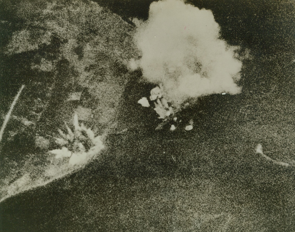 DEATH OF THE TIRPITZ--#2, 11/17/1944. Clouds of smoke envelope the 45,000-ton German battleship Tirpitz as bombs strike home during the Nov. 12 raid by a fleet of 32 RAF Lancaster bombers. Huge dreadnaught can be seen in center of photo at base of large smoke column. The ship was later seen to heel over in the shallow waters of Tromso Fjord, Norway, after at least three 12,000-pound bombs scored direct hits. Smoke mushrooms up at left center as a stray bomb strikes the land.  Credit (British Official Photo from ACME);