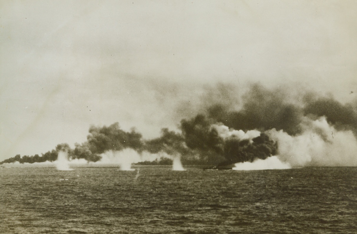 Japs Miss the Boats, 11/17/1944. Water spouts produced by shells fired from badly battered Nip Flotilla, land near two U.S. Destroyers laying smoke screen for Carriers moving into action. Scene occurred during second battle of the Philippine Sea as Japs tried to intercept additional landings of Yank troops. Credit: U.S. Navy photo from ACME;
