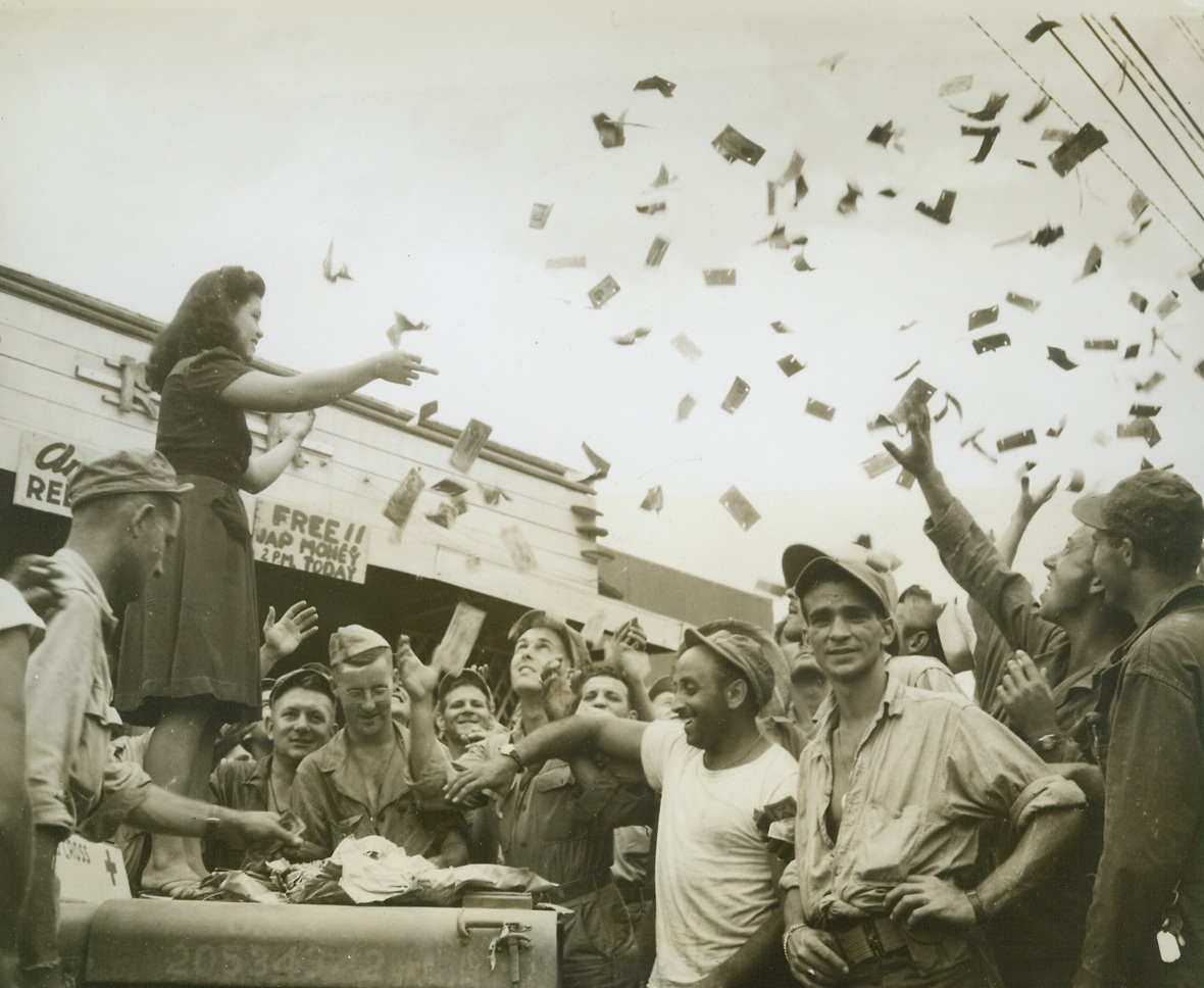 Jap Money - -For Free, 11/15/1944. Leyte- - When civil authorities encouraged the disposing of 4,000,000 valueless pesos in Jap invasion currency, a Red Cross party was held and the worthless cash thrown to American soldiers and sailors.  In Tacloban, they are shown grabbing for “pesos from heaven.”  This is one of the last pictures made by Acme Photographer, Frank Prist, Jr., for the War Picture Pool, who was instantly killed by a Japanese sniper bullet in Western Leyte.Credit-WP-(ACME);