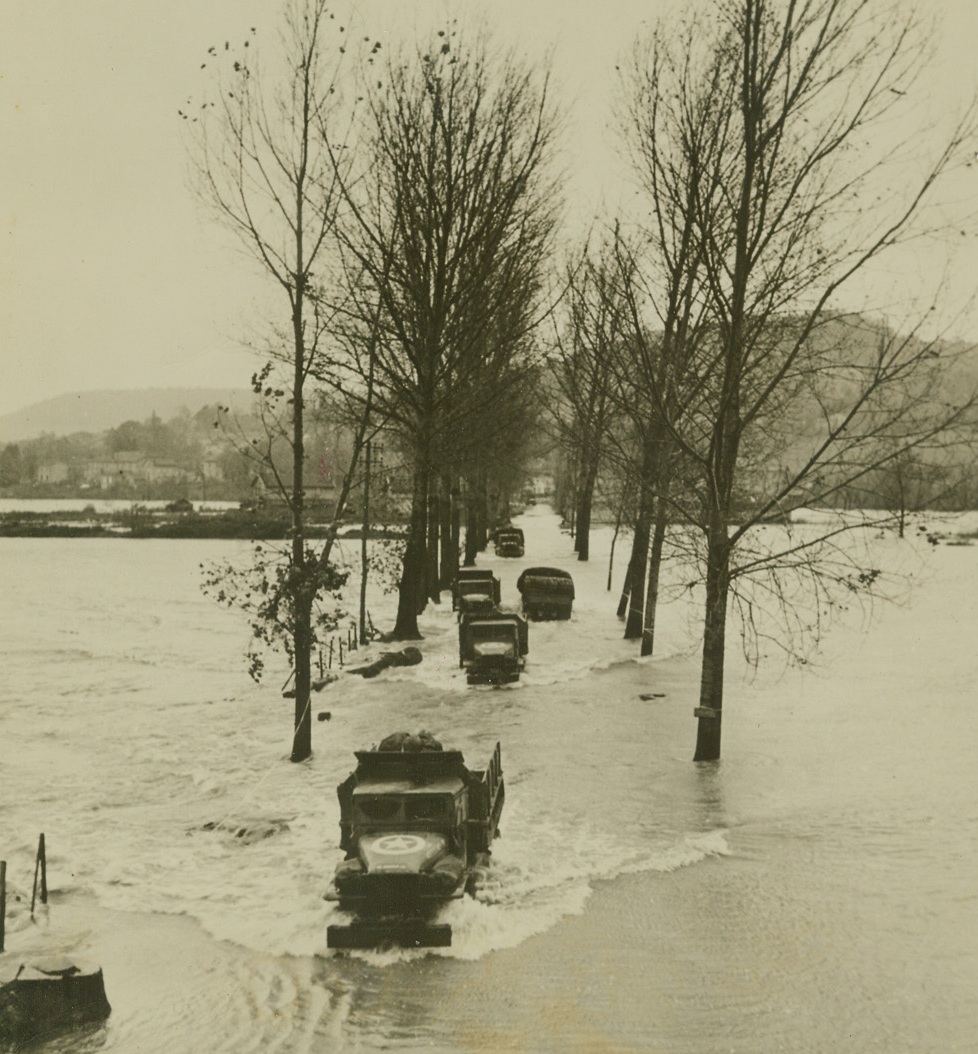 Misery at Metz, 11/17/1944. France – U.S. 3rd Army trucks make their way through engine deep flood waters cause by the winter rains in central France. This is a sample of the weather hazards in which General Patton has started his new offensive around Metz. Credit: ACME;