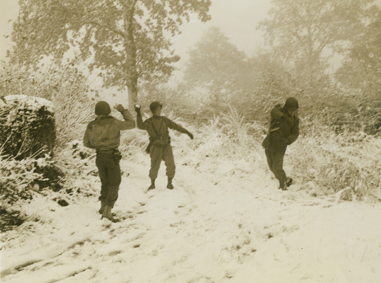 /Mock Battle on Real Battlefront, 11/18/1944. Germany – Laying down their lethal weapons for a time, these Yanks have a great deal more fun staging a snowball fight, after the fall of the first heavy snow that marked the beginning of winter for Americans with the 1st Army in Germany. Credit: ACME photo by Andrew Lopez, War Pool Correspondent;