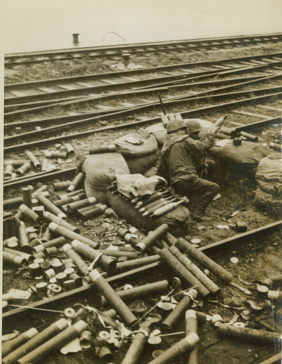 TANKS BOMBARD RHINE CITY, 12/27/1944. FRANCE – A mortar crew of the U.S. 7th Army fired shells at the German city of Kehl, across the Rhine River from their hastily-erected sandbag position in the Strasbourg railway yards. The Germans had destroyed the three bridges spanning the Rhine between the two cities. (Passed by censors.) Credit: ACME;