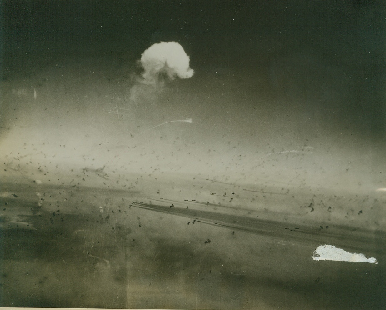 Flak-Filled Skies, 12/7/1944. This remarkable photo taken as U.S. Army 8th Air Force B-17 Flying Fortresses flew over Germany headed for oil targets at Merseberg, shows the huge amount of flak that desperate Nazi anti-aircraft gunners are putting into the skies these days. White clouds (top, center) is all that remains of one Fortress that received a direct hit. The contrails of other planes can be seen below the cloud and across the center of the photo.Credit Line (U.S.A.A.F Photo from Acme);