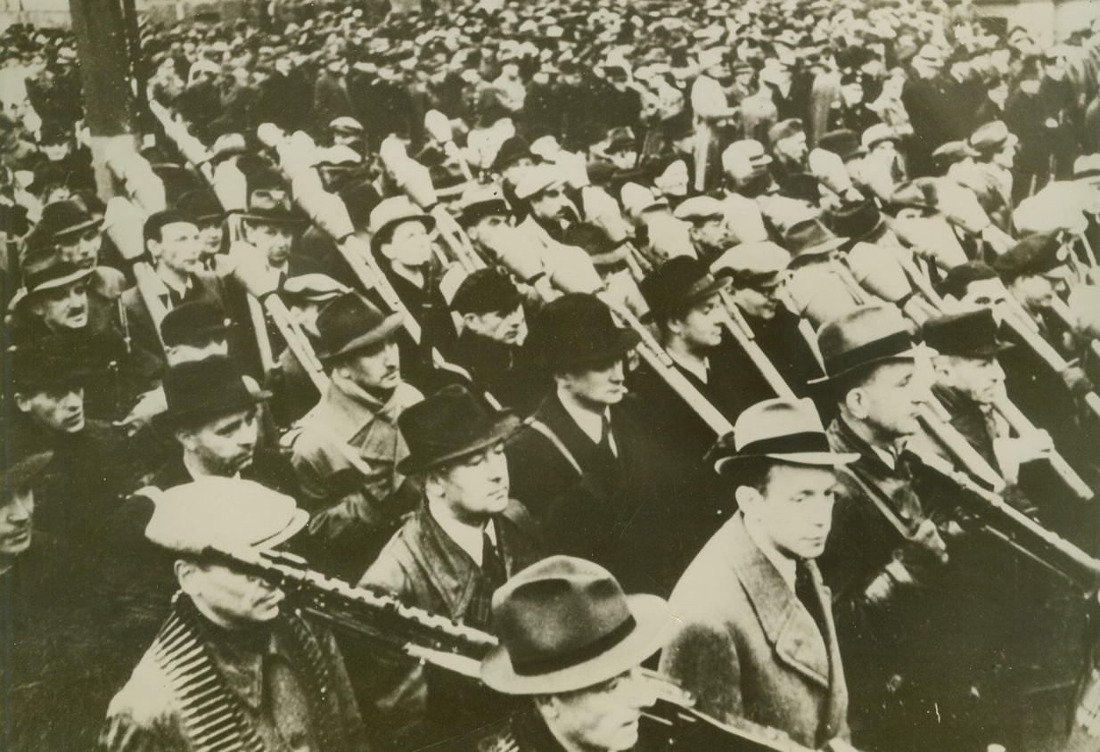 Germany’s Home Guard Exercises, 12/8/1944. GERMANY – Wearing civilian clothing and carrying military weapons, members of the German “Volksturm” (home guard) parade in Berlin as they were ceremoniously sworn in to defend the Fatherland to the death. Dr. Goebbels reviewed the parade. The mace-like weapons carried by some of the “soft hat brigade” are anti-tank rocket projectiles.Credit – WP- (Acme);