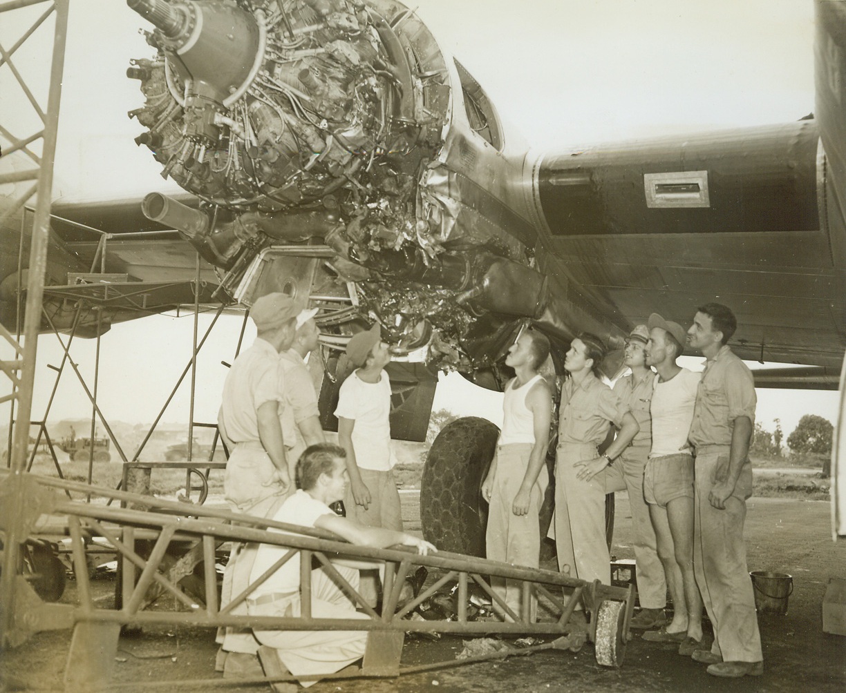 After Jap Plan Rammed Superfort, 12/14/1944. Saipan – Crew members of a B-29 Superfortress examine damage to one of the ship’s engines, rammed head-on by a Jap Tony fighter, during a raid on Japan, Dec 3.  The Nip’s wing was sheared off, it crashed into another Jap and both went down in flames.  The Superfort returned to its Saipan base on three engines.  Left to right, are: Cpl, Joseph C. Cook, of Tajunga, Calif., gunner, (kneeling); and (standing); Lt. Donald J. Dufford, Grand Junction, Colo., plane commander; Lt. Drayton K. Finney, Miles, Ohio, navigator; Cpl. George P. McGraw, Titusville, PA., gunner; Sgt. Robert H. Jay, Hobson, Mont., gunner; Sgt. Don M. Frensley, Duncan, Okla., radio operator; Lt. Roger S. Kolb, Spencer, Ind., flight engineer; Sgt. R.V. Rainer, Grossbeck, Texas, gunner; and Sgt. Salvatore A. Tabtaglione, New York, N.Y., central fire control gunner.Credit line (ACME);